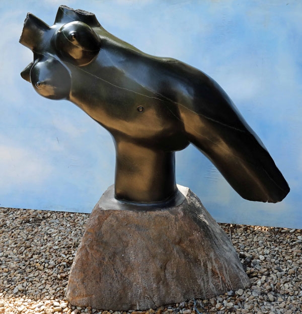 Unique springstone sculpture of a female torso resting on one leg and leaning over