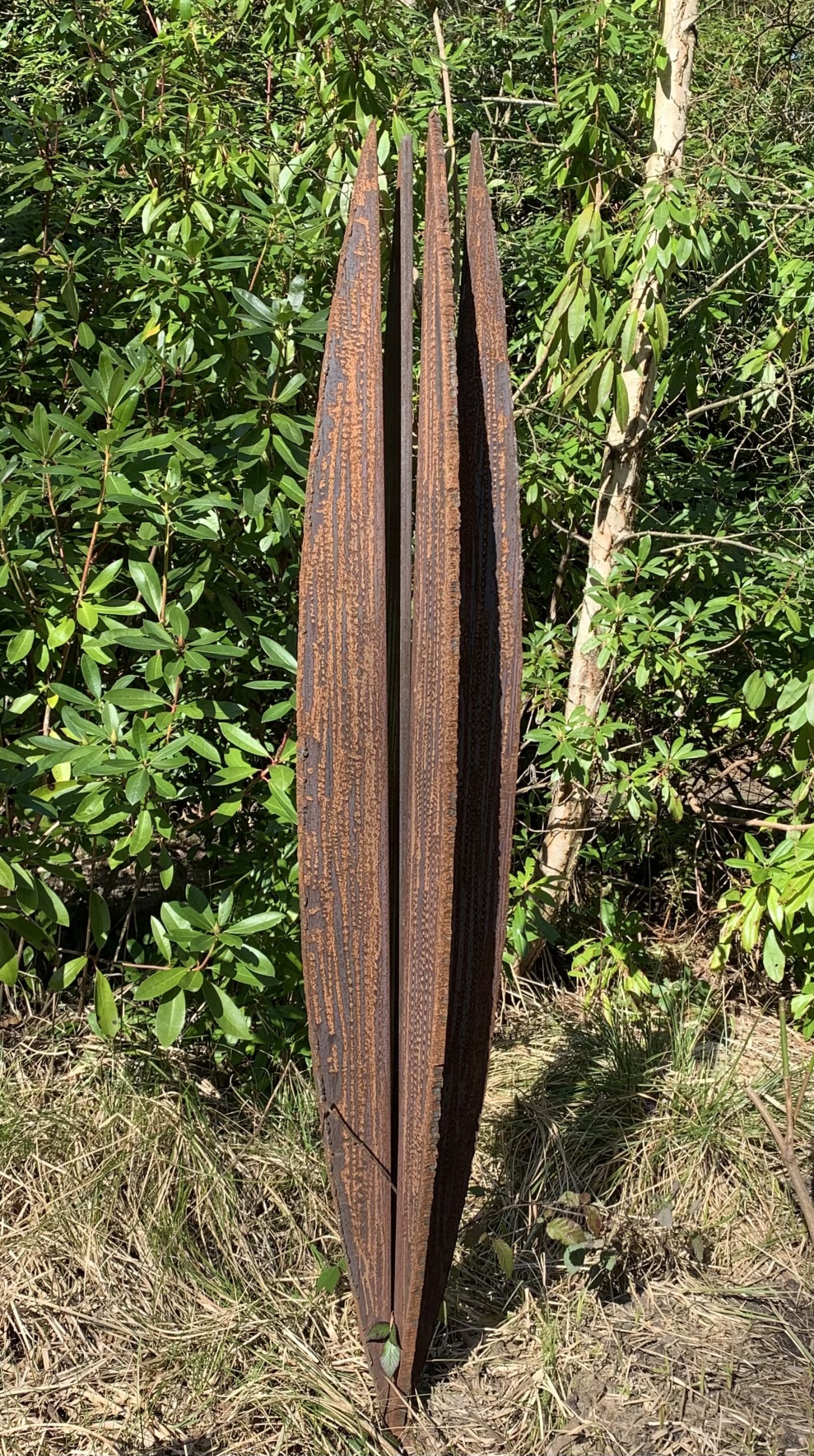 A abstract steel sculpture of an metal shape resembling a cypress tree.