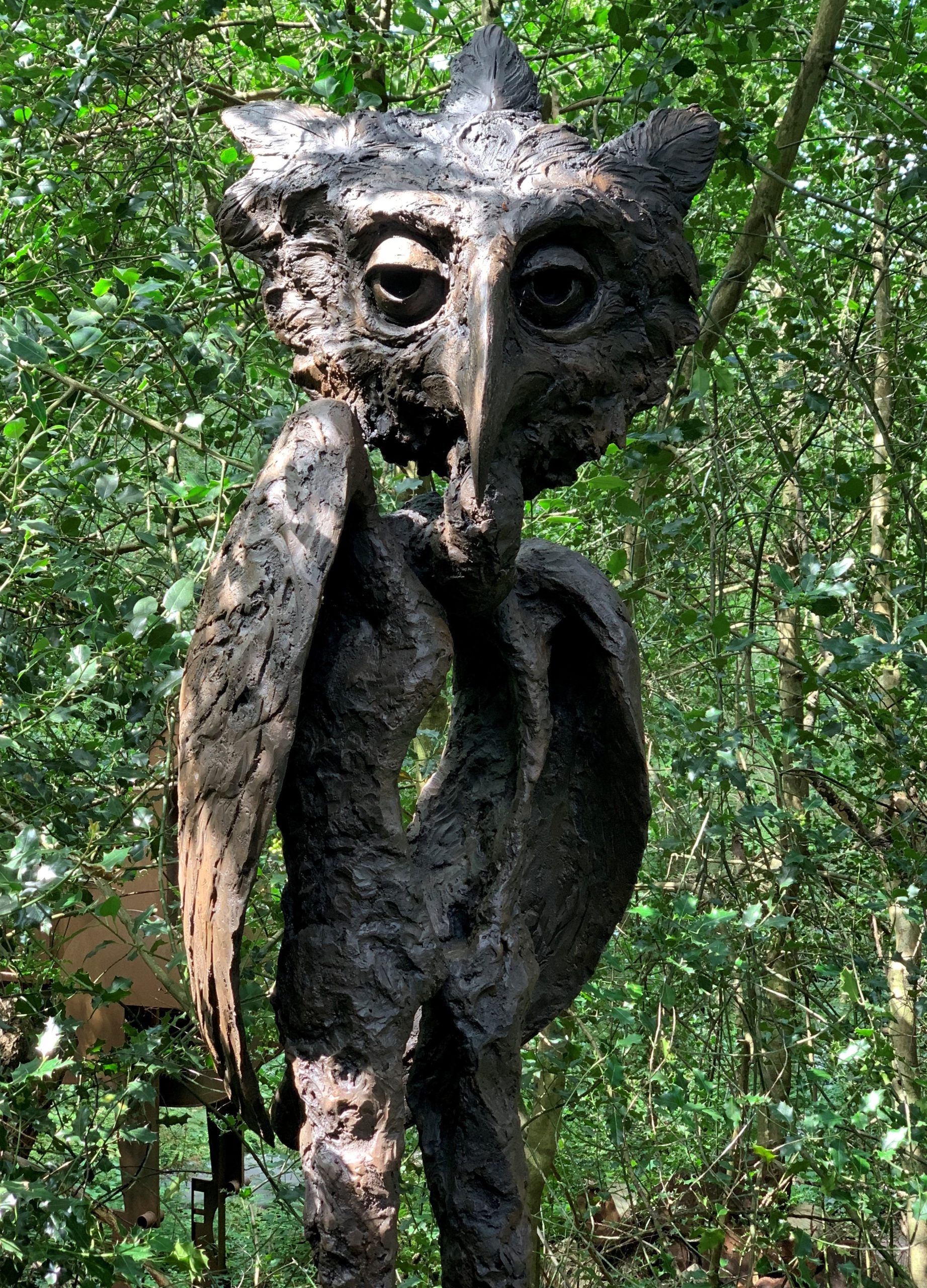 A steel and resin sculpture of a mix between and owl and a man.