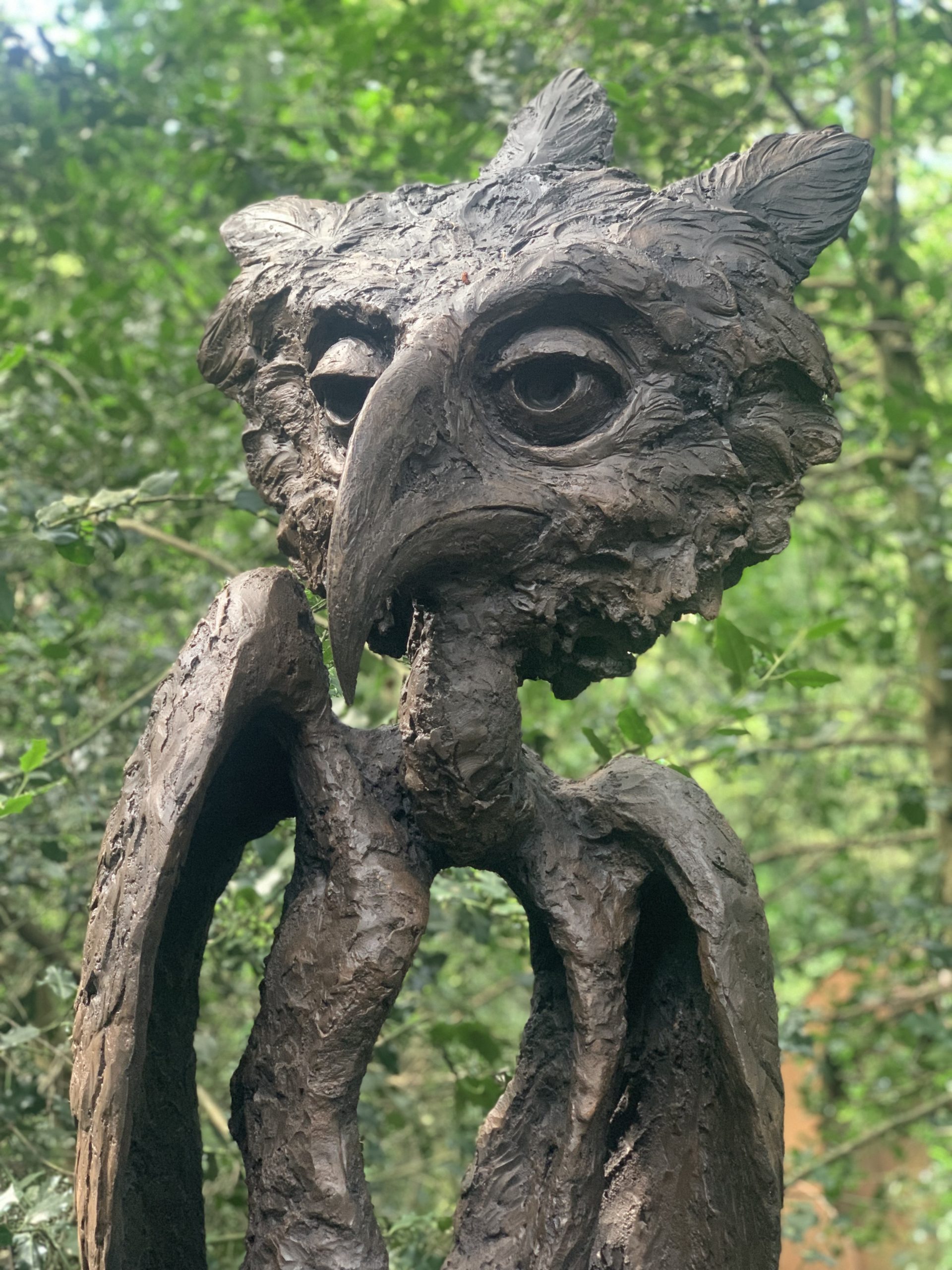 A steel and resin sculpture of a mix between and owl and a man.