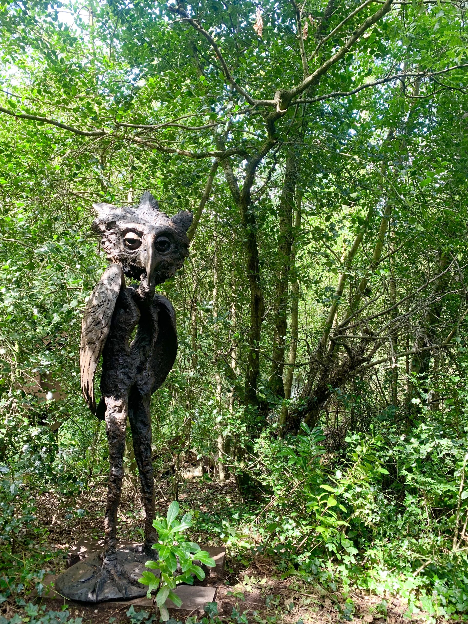 A steel and resin sculpture of a mix between and owl and a man.