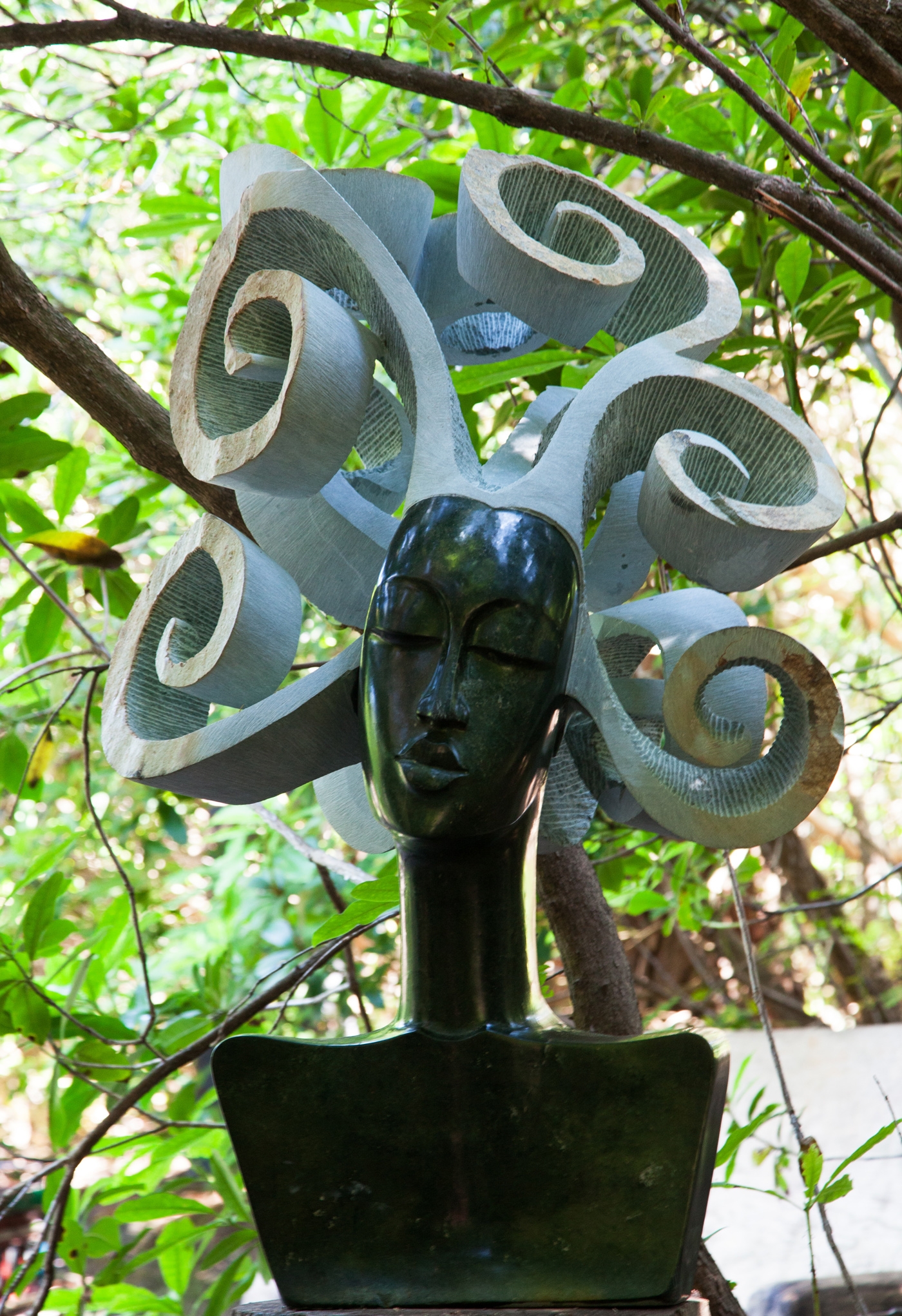 Loving my Curls by David White is A larger scale Shona sculpture of a woman's head with big curly hair.