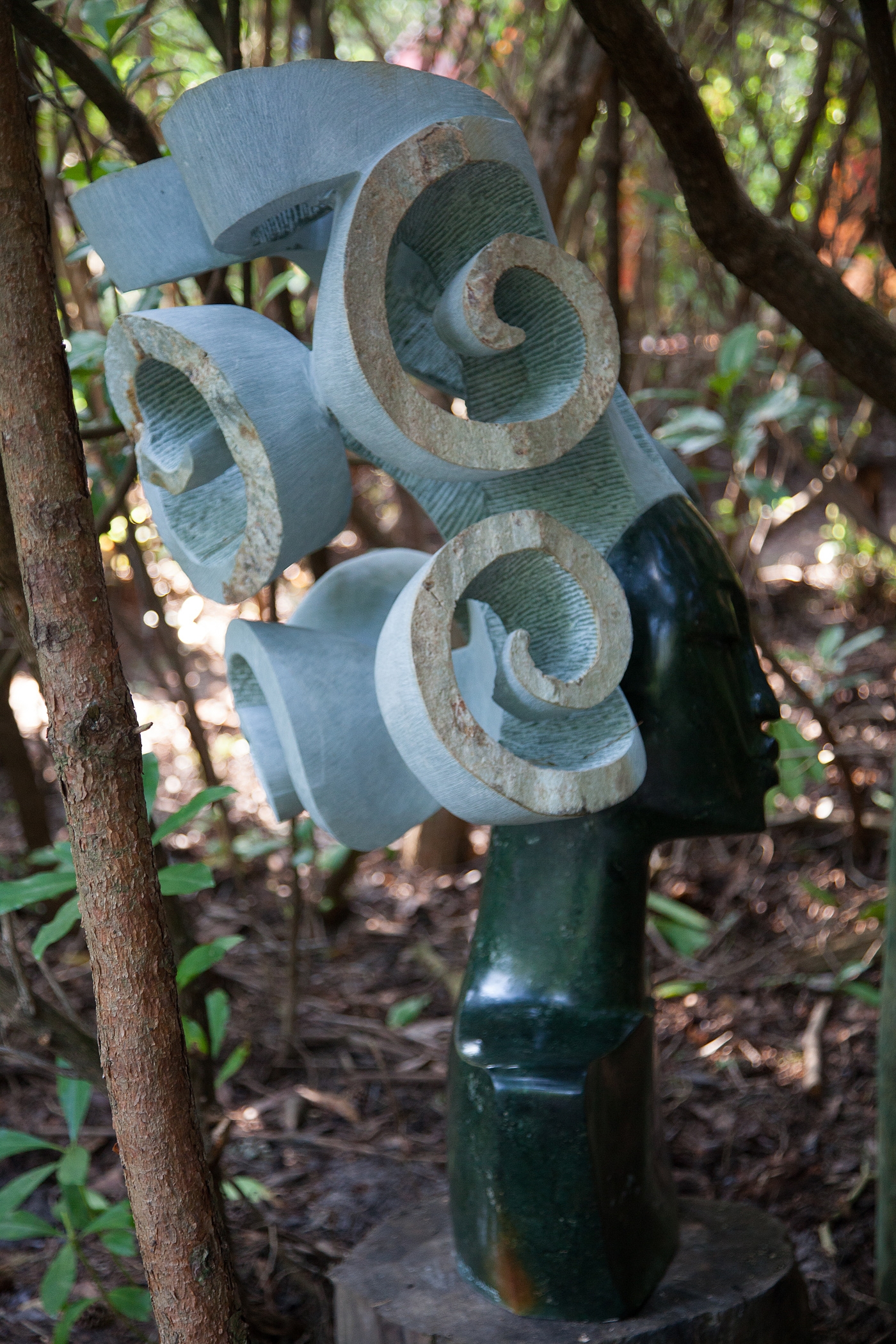 A larger scale Shona sculpture of a woman's head with big curly hair.