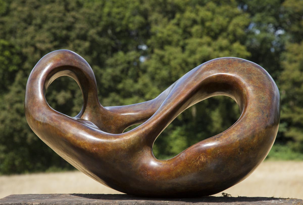 A figurative bronze sculpture of a shape reclining back in a relaxed manner.