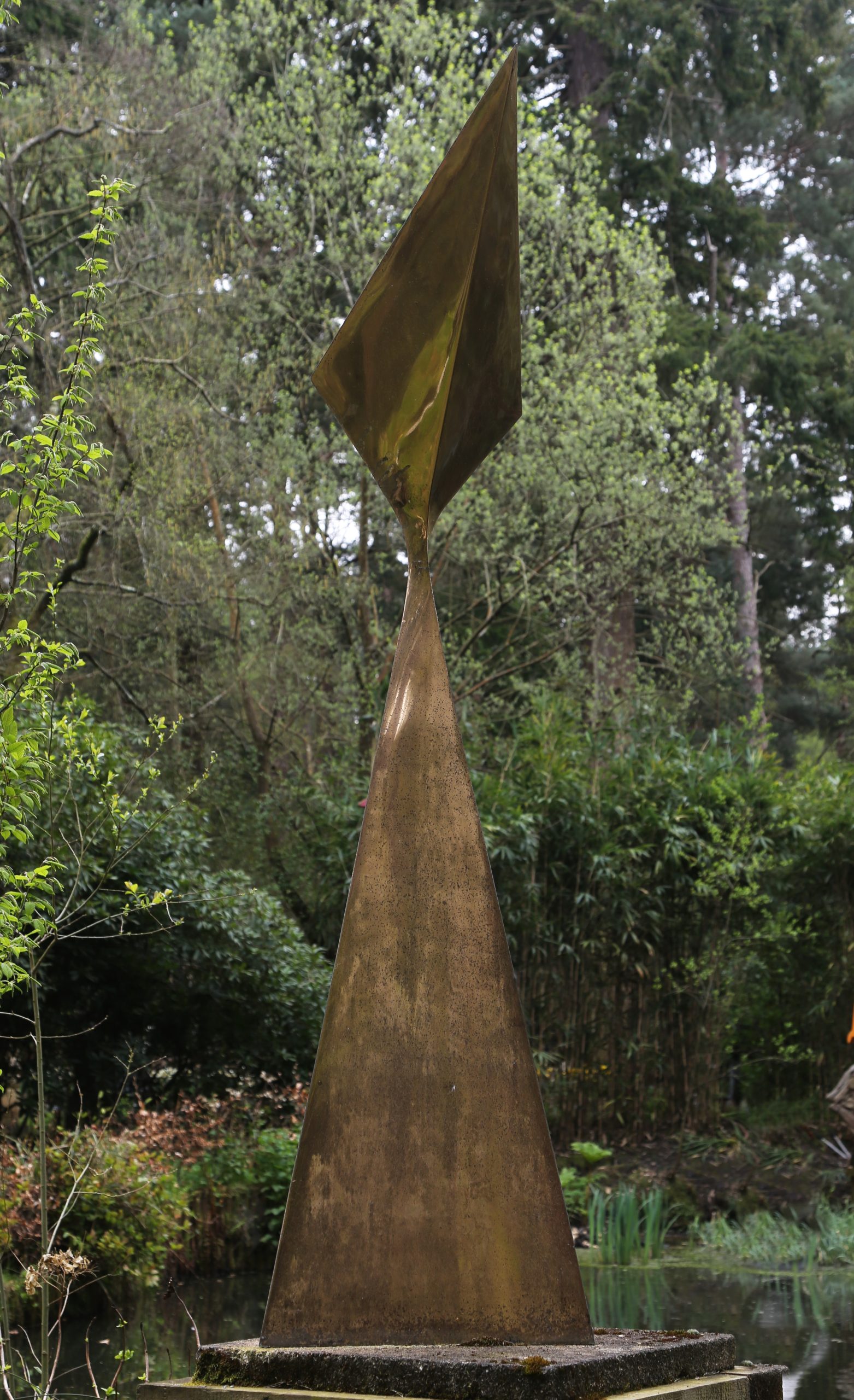A abstract bronze sculpture of a large triangular shaped structure.