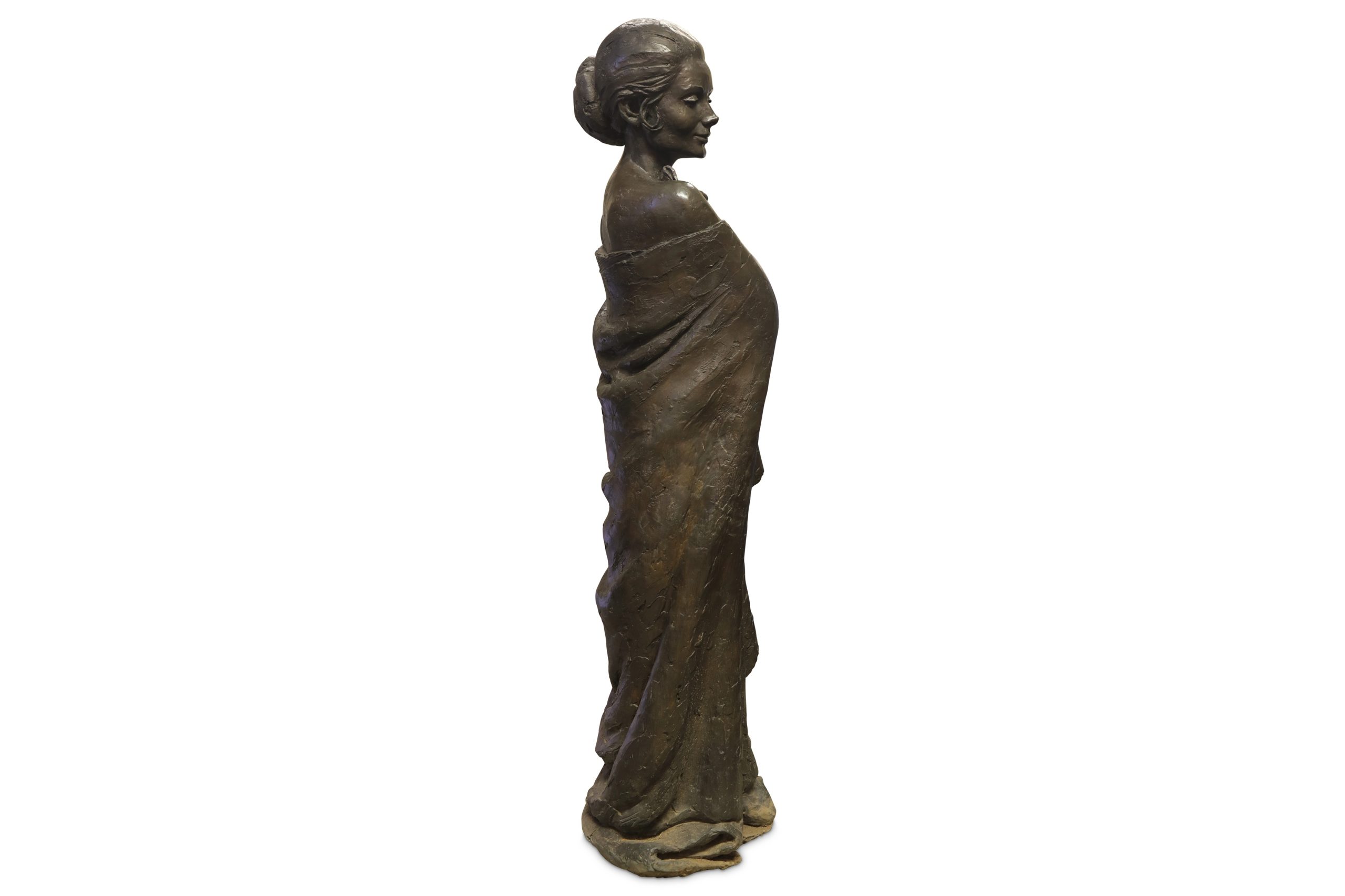 A bronze with black patina sculpture of a woman smiling and wearing a cloak.