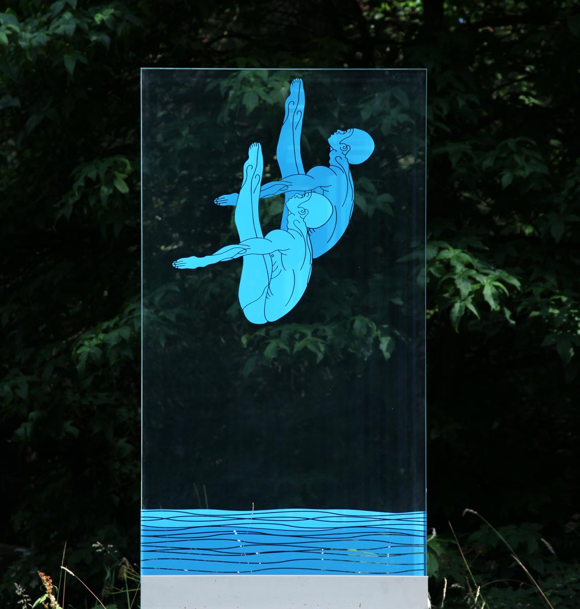 A pop art glass sculpture of a plain of glass showing two figures in the middle of diving.