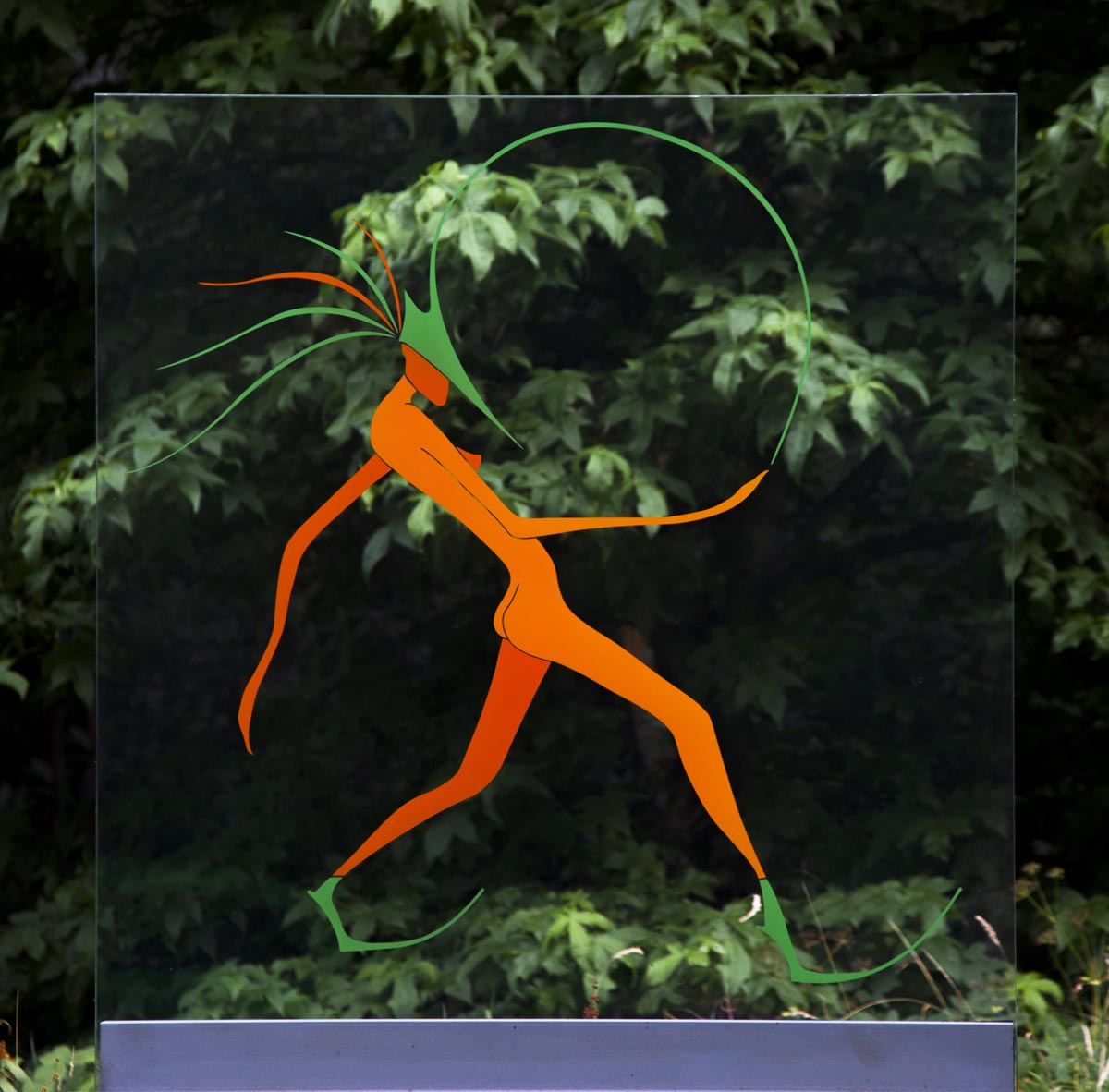 A pop art glass sculpture of a plain of glass with an abstract figure strutting forwards.
