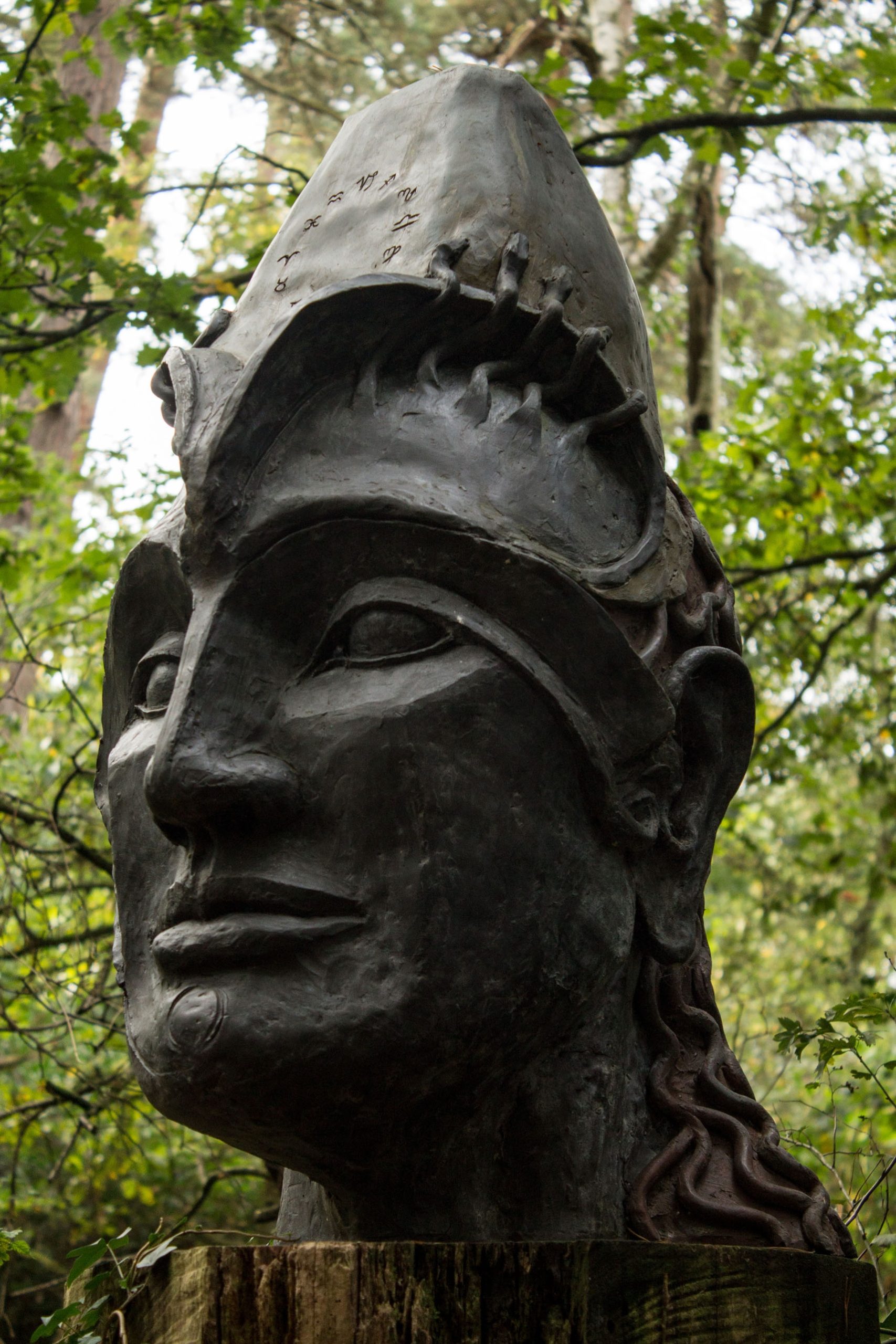 A figurative bronze resin sculpture of a portrait of a mans head.