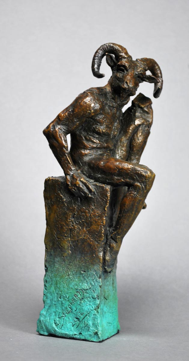 A figurative bronze sculpture of a man with a rams head sat casually on a ledge.
