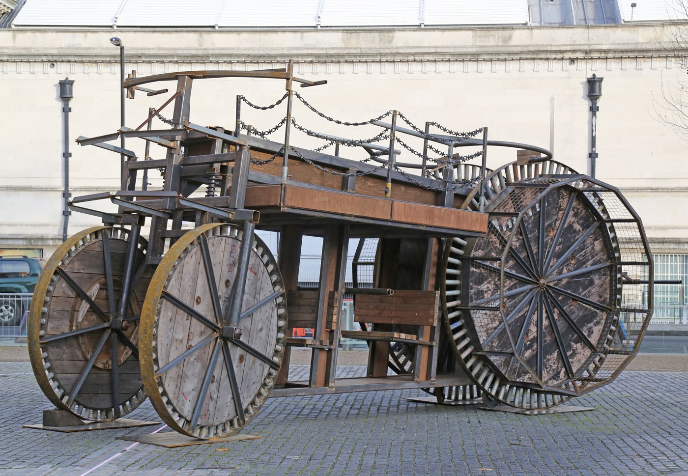 A expressionism steel and wooden sculpture of a large automobile.