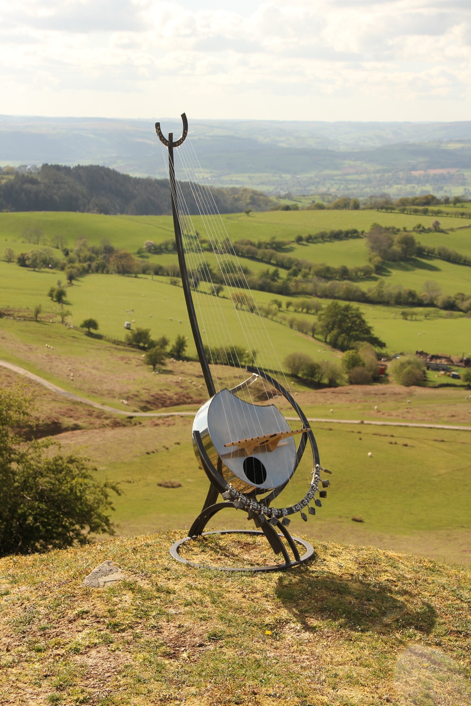 A abstract metal sculpture of a guitar mounted onto a stand.