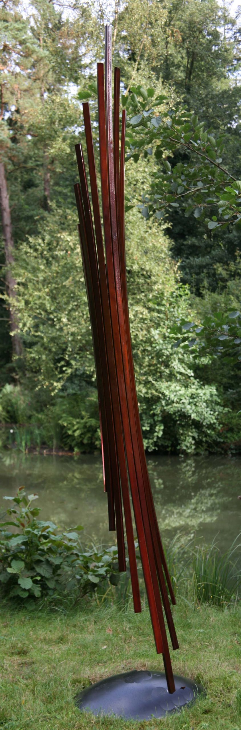 A abstract stainless steel sculpture of a fanned out shape rolled into a cylinder.