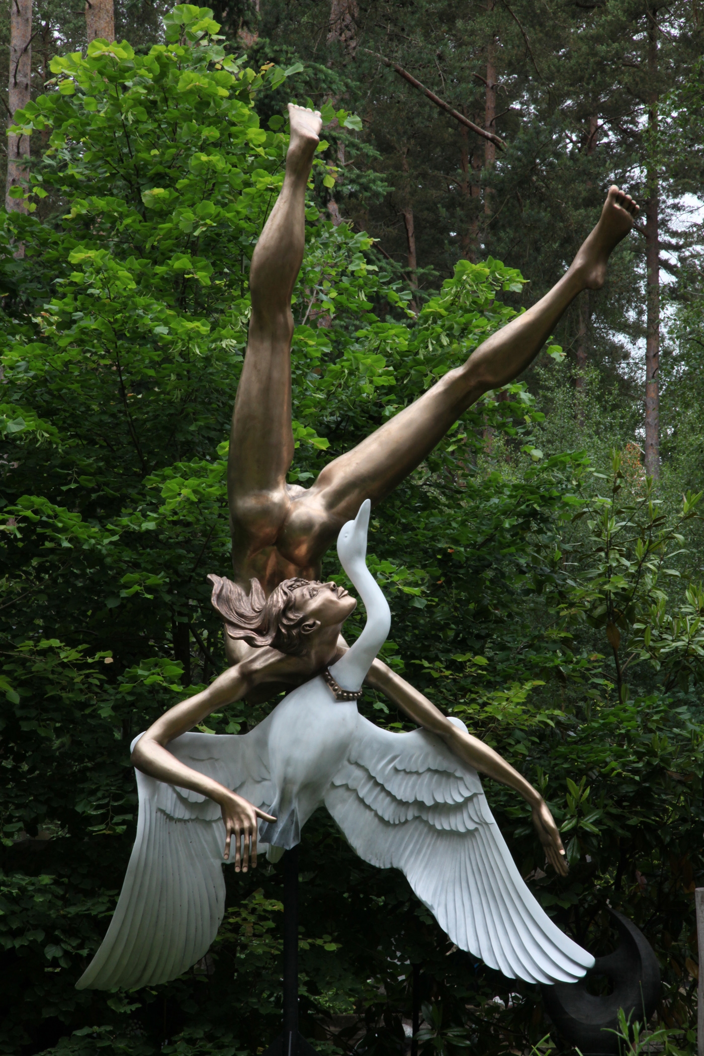 A monumental bronze and phenolic sculpture of a golden lady falling through the sky with a swan.
