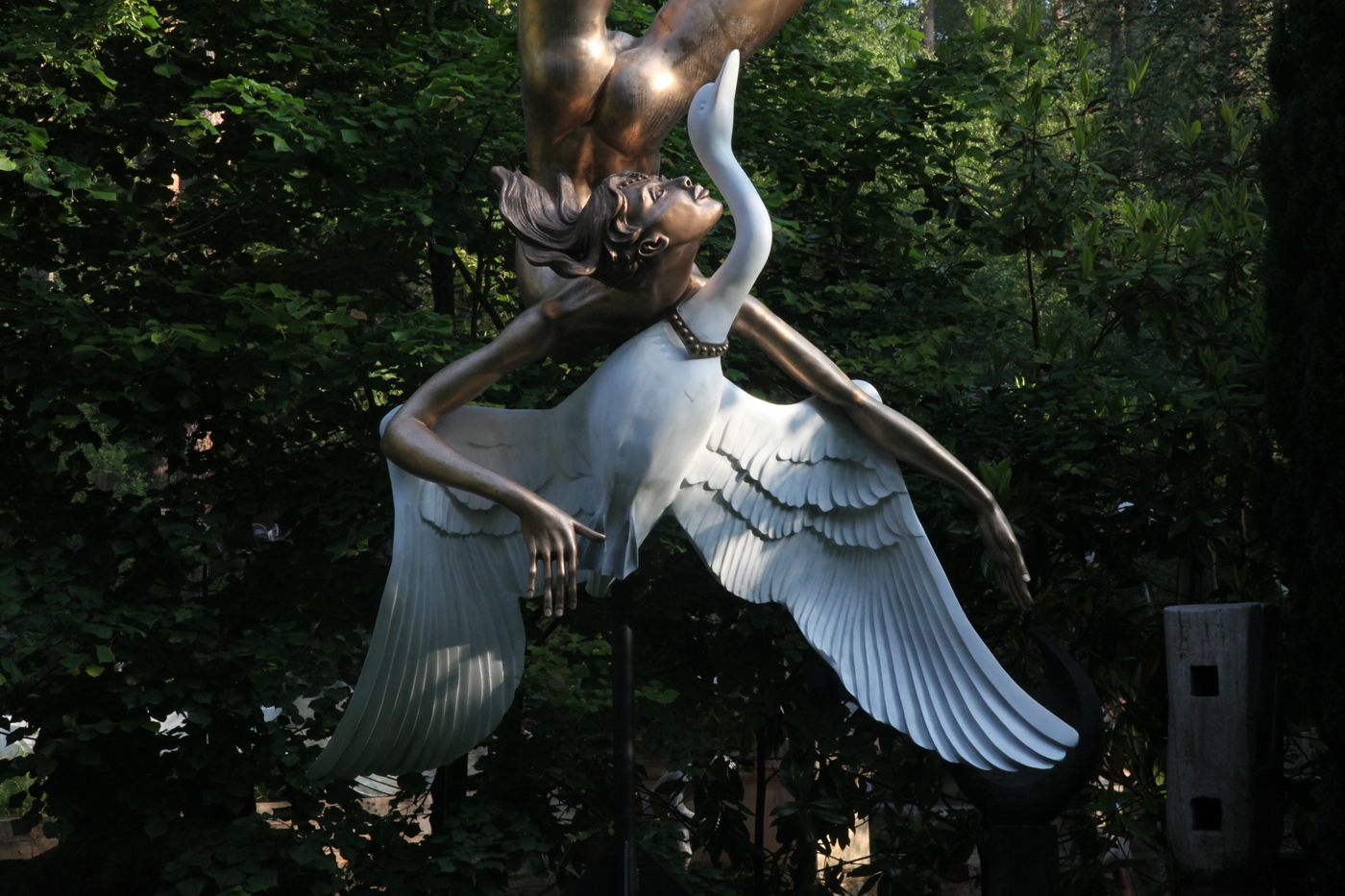 A monumental bronze and phenolic sculpture of a golden lady falling through the sky with a swan.