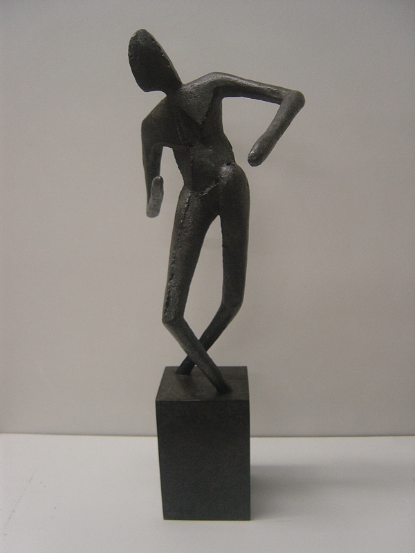 A figurative bronze sculpture of a person standing and looking around.