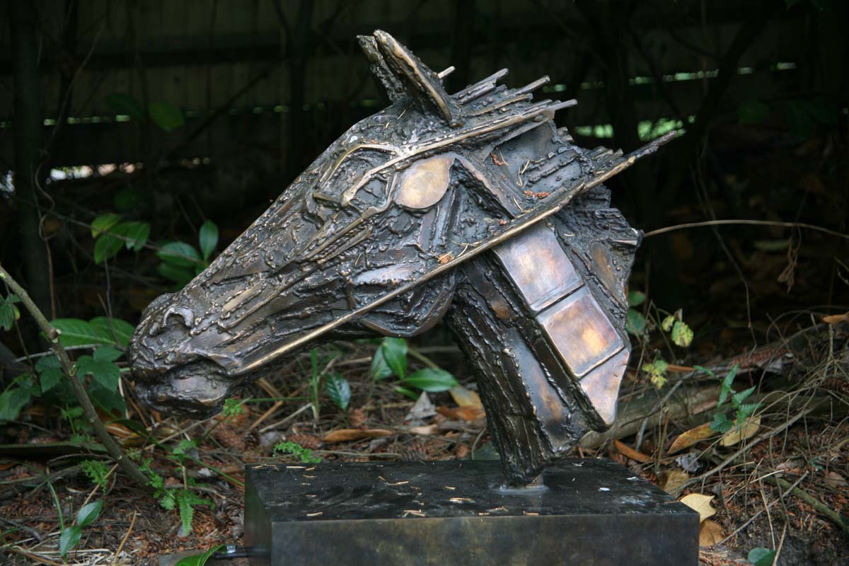 A impressionism bronze sculpture of a horses head caught in motion.