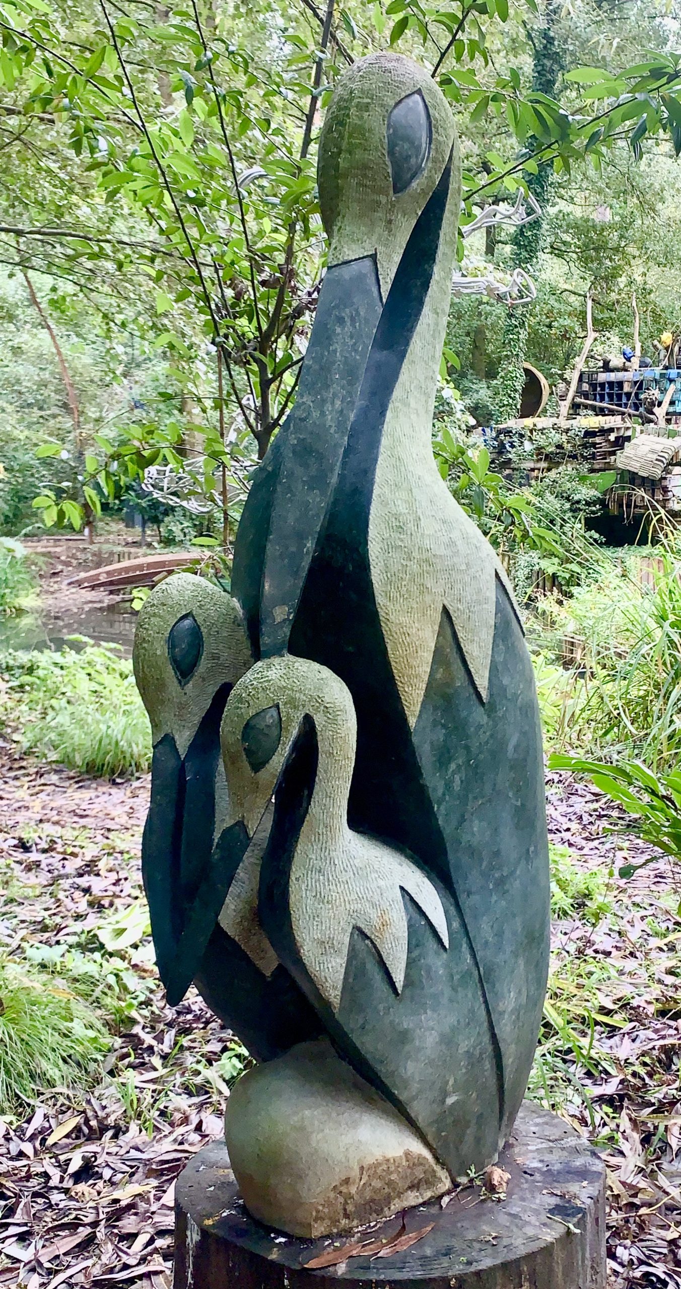 A shona opal stone sculpture of a bird with two smaller birds together as a family.