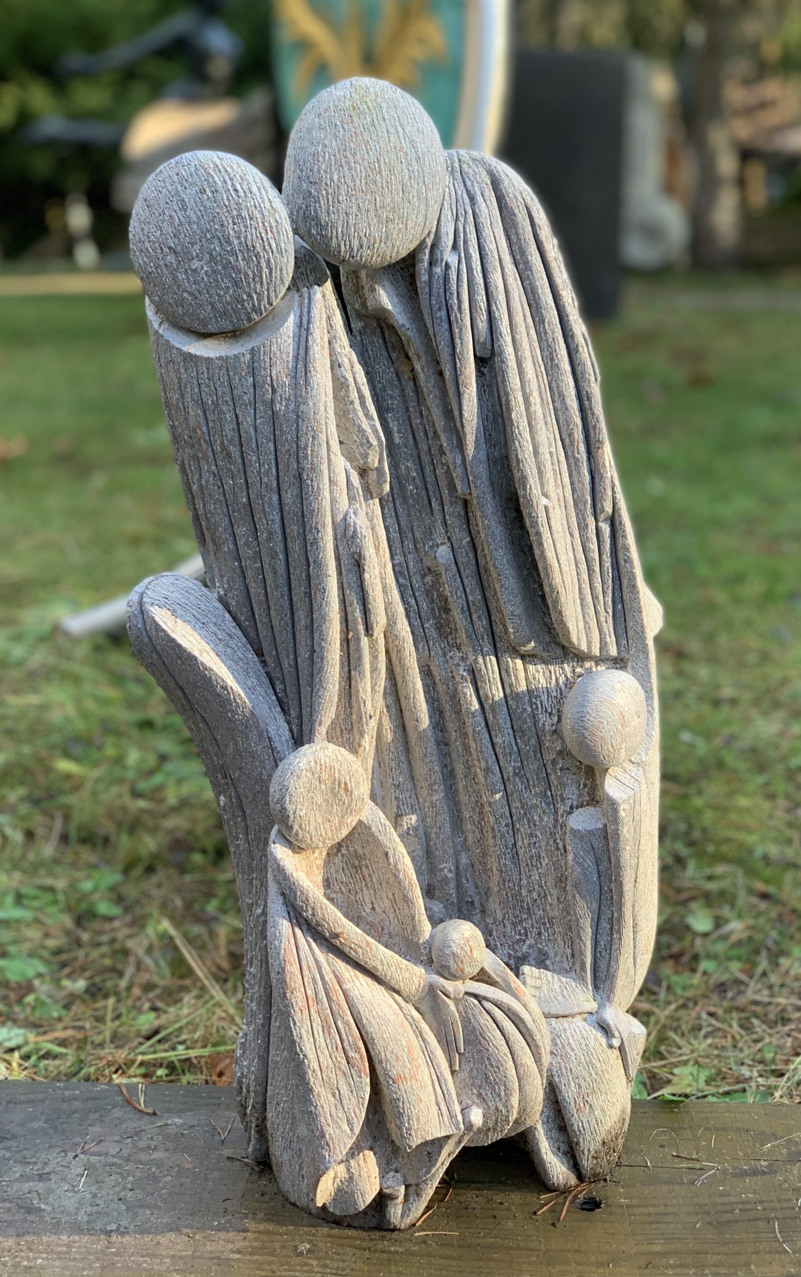 An abstract Shona sculpture of a family of three, made of Serpentine stone.