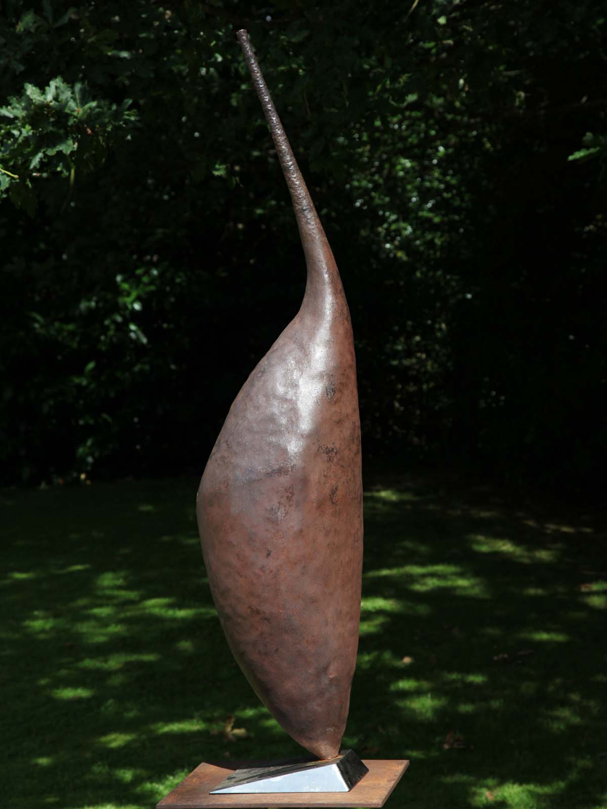 A modern beaten and stainless steel sculpture of an abstract depiction of an emperor penguin.