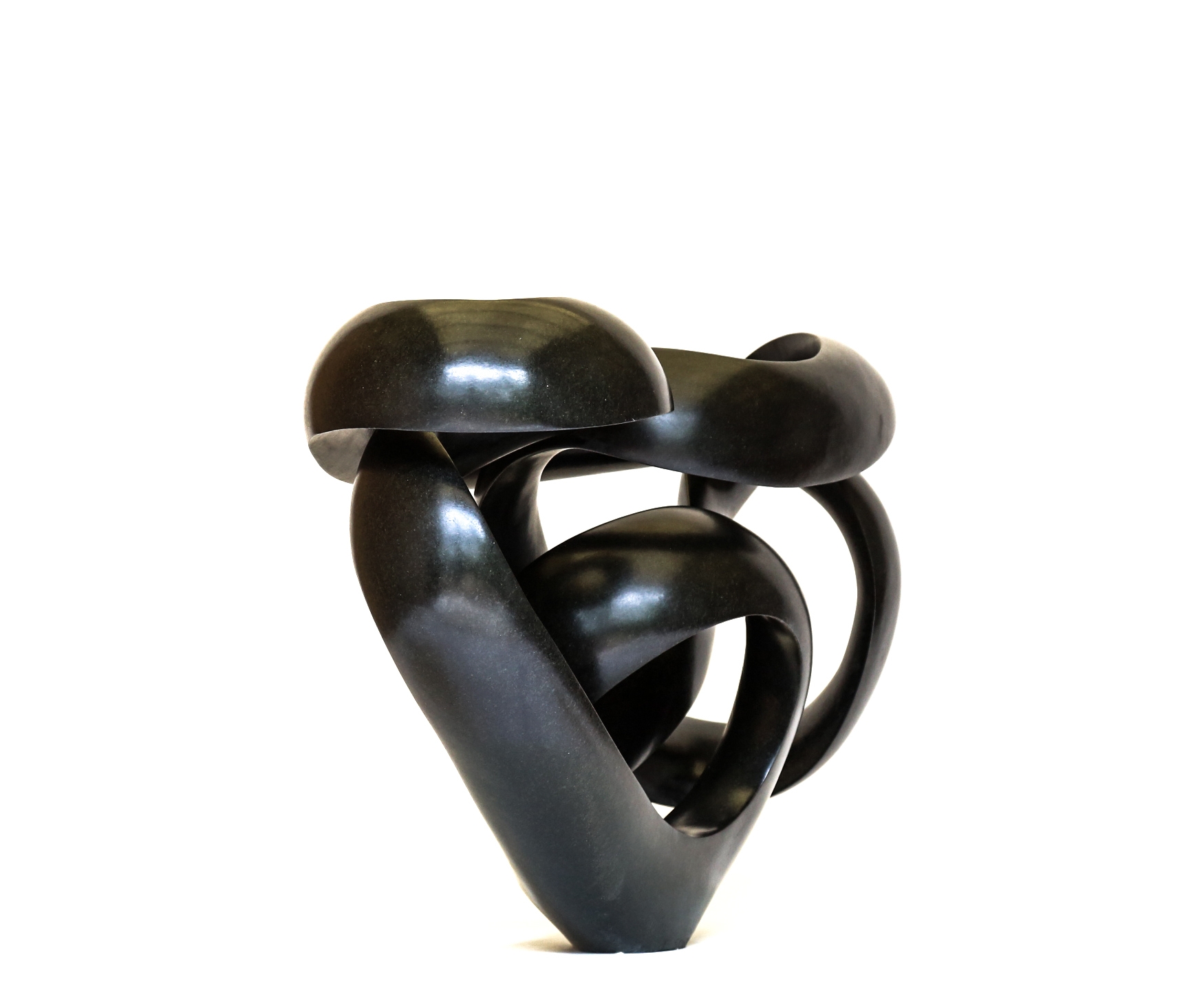 A shona springstone sculpture of a curving and twisting abstract shape.