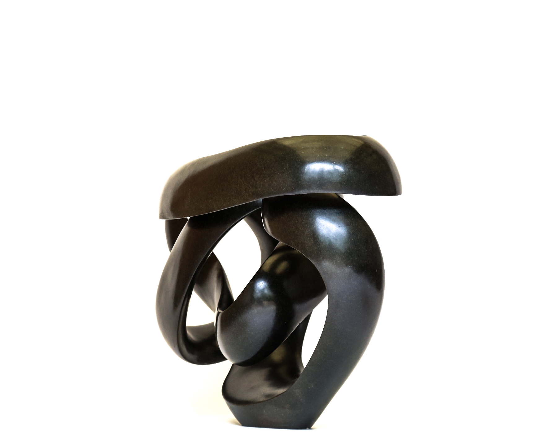 A shona springstone sculpture of a curving and twisting abstract shape.