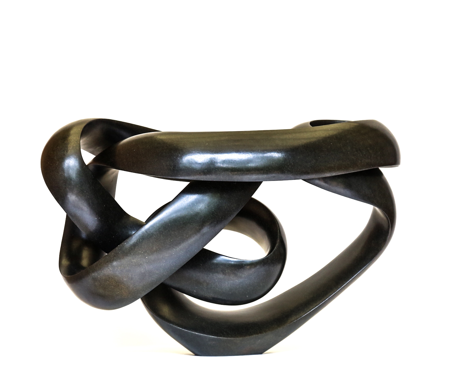 A shona springstone sculpture of a curving and twisting abstract shape.