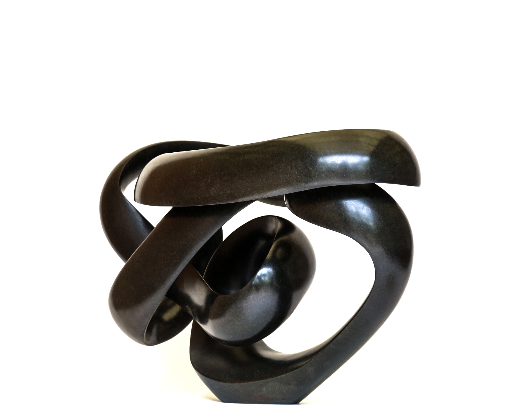 A shona springstone sculpture of a curving and twisting abstract shape.