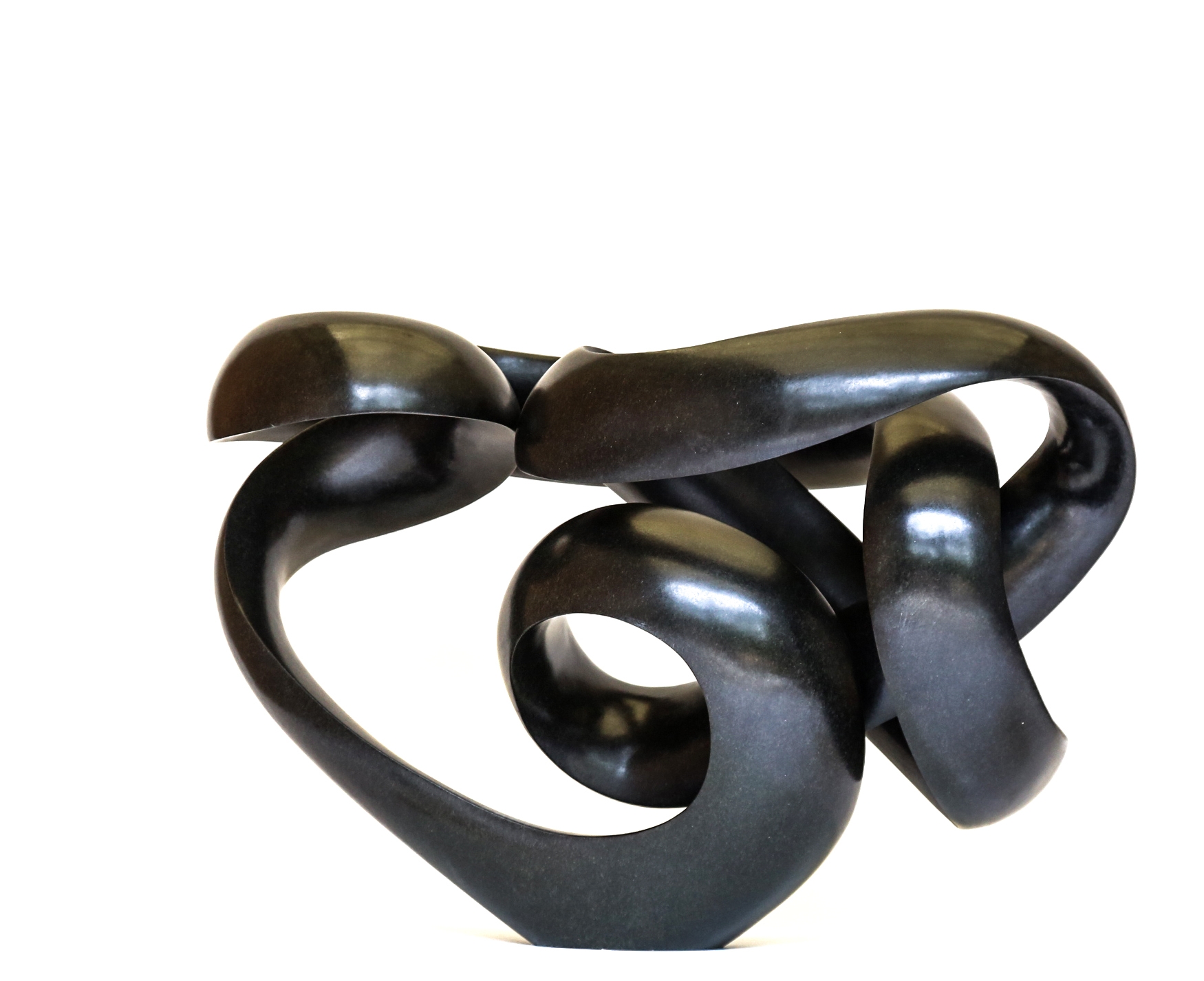 A shona springstone sculpture of a curving and twisting abstract shape.