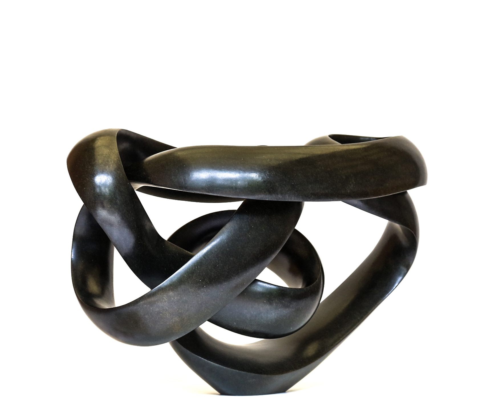 A shona springstone sculpture of a curving and twisting abstract shape.