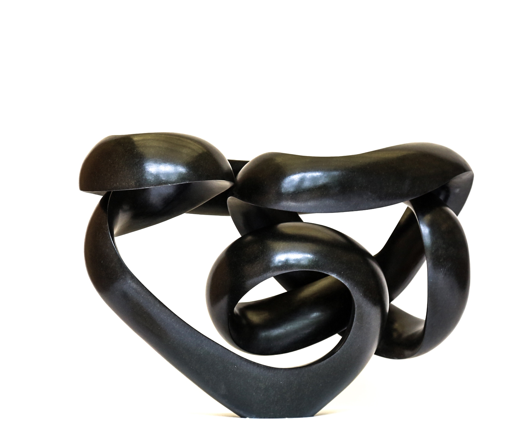 A shona springstone sculpture of a curving and twisting abstract shape.
