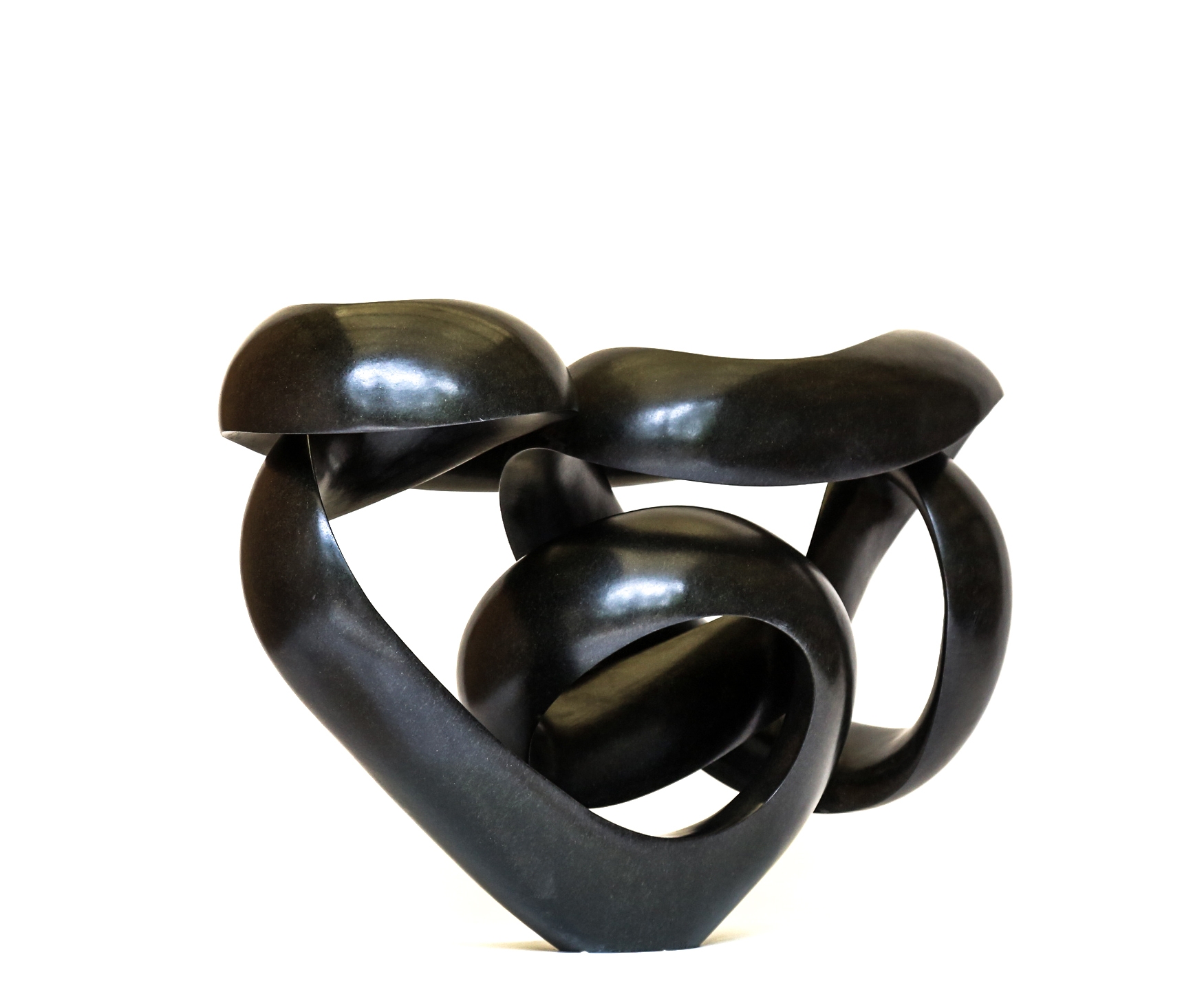 A shona springstone sculpture of a curving and twisting abstract shape.