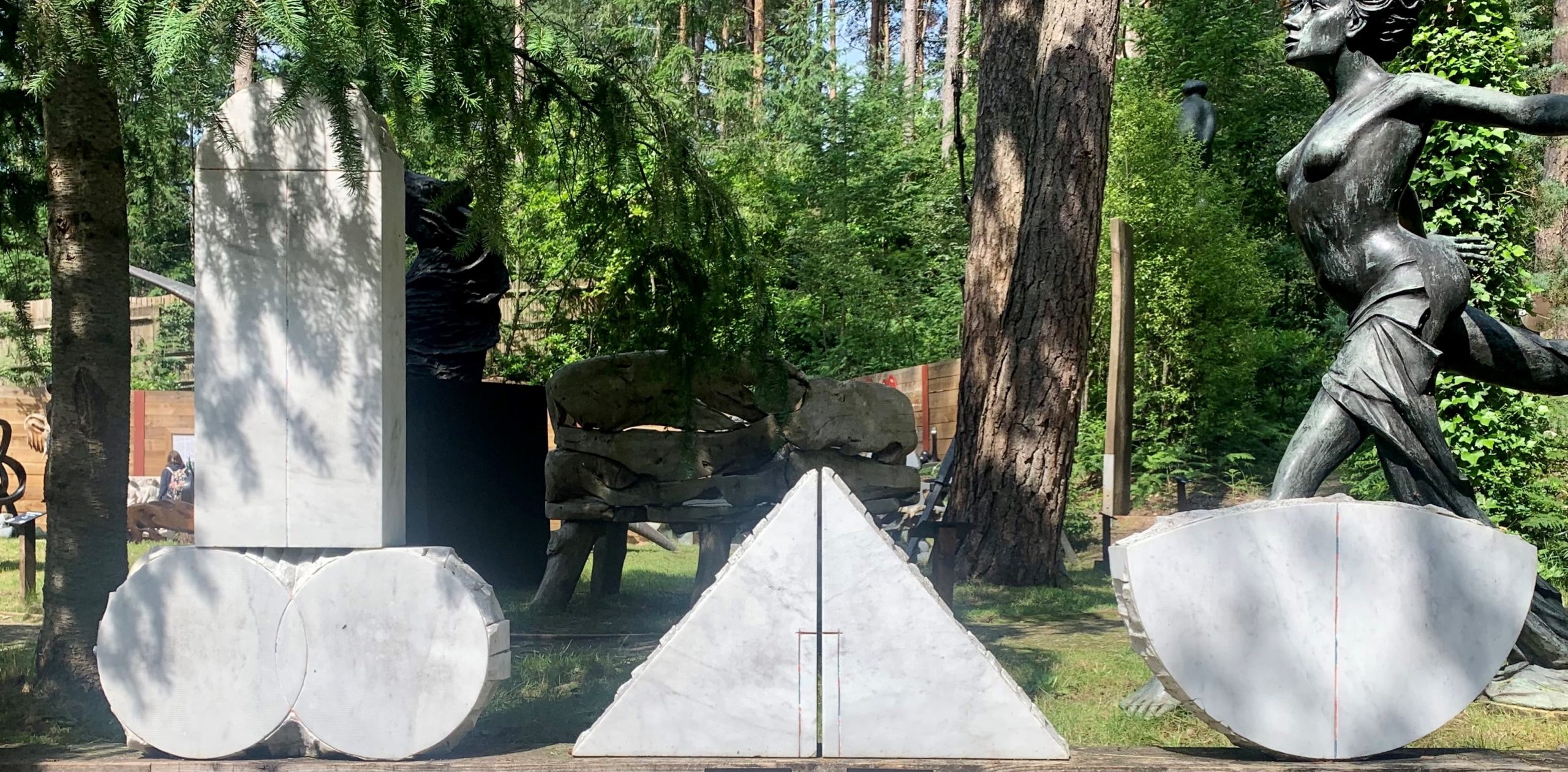 A abstract marble sculpture of a set of three different shapes all together.