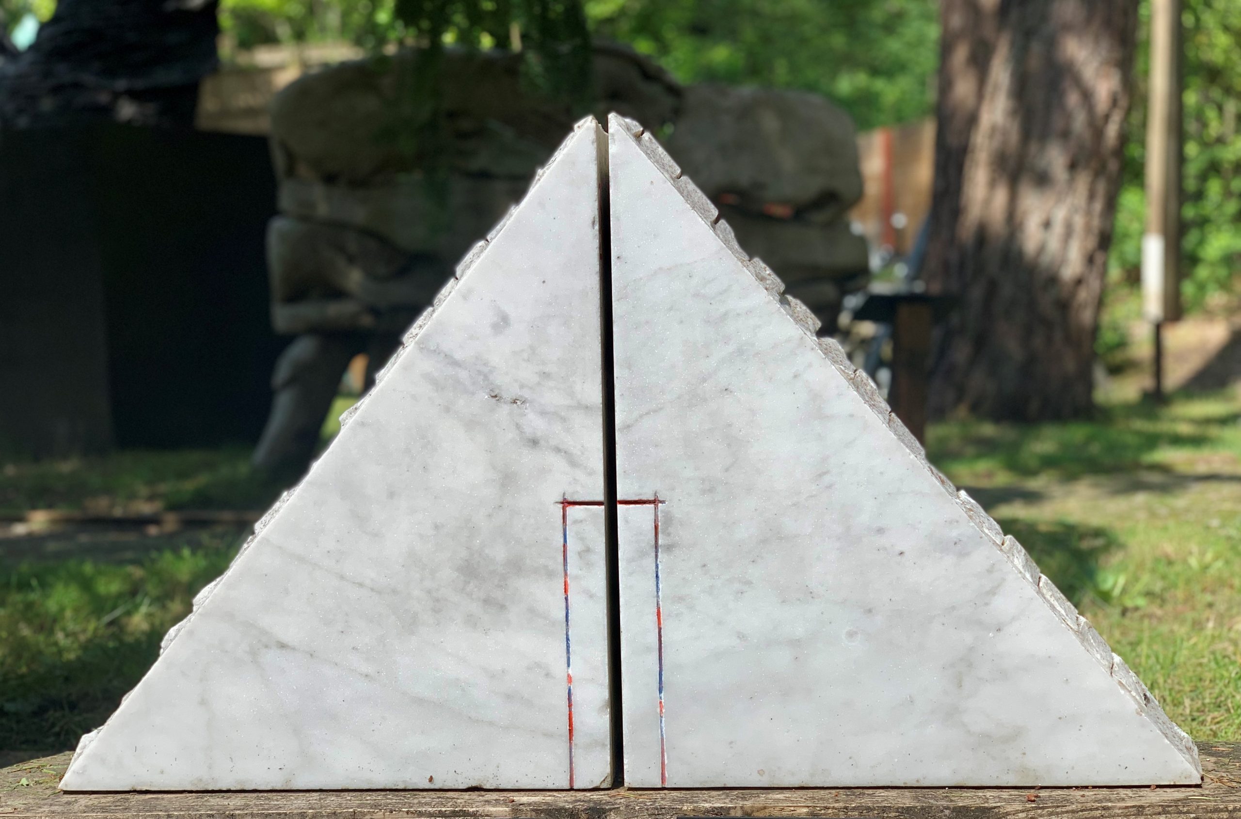 A abstract marble sculpture of a set of three different shapes all together.