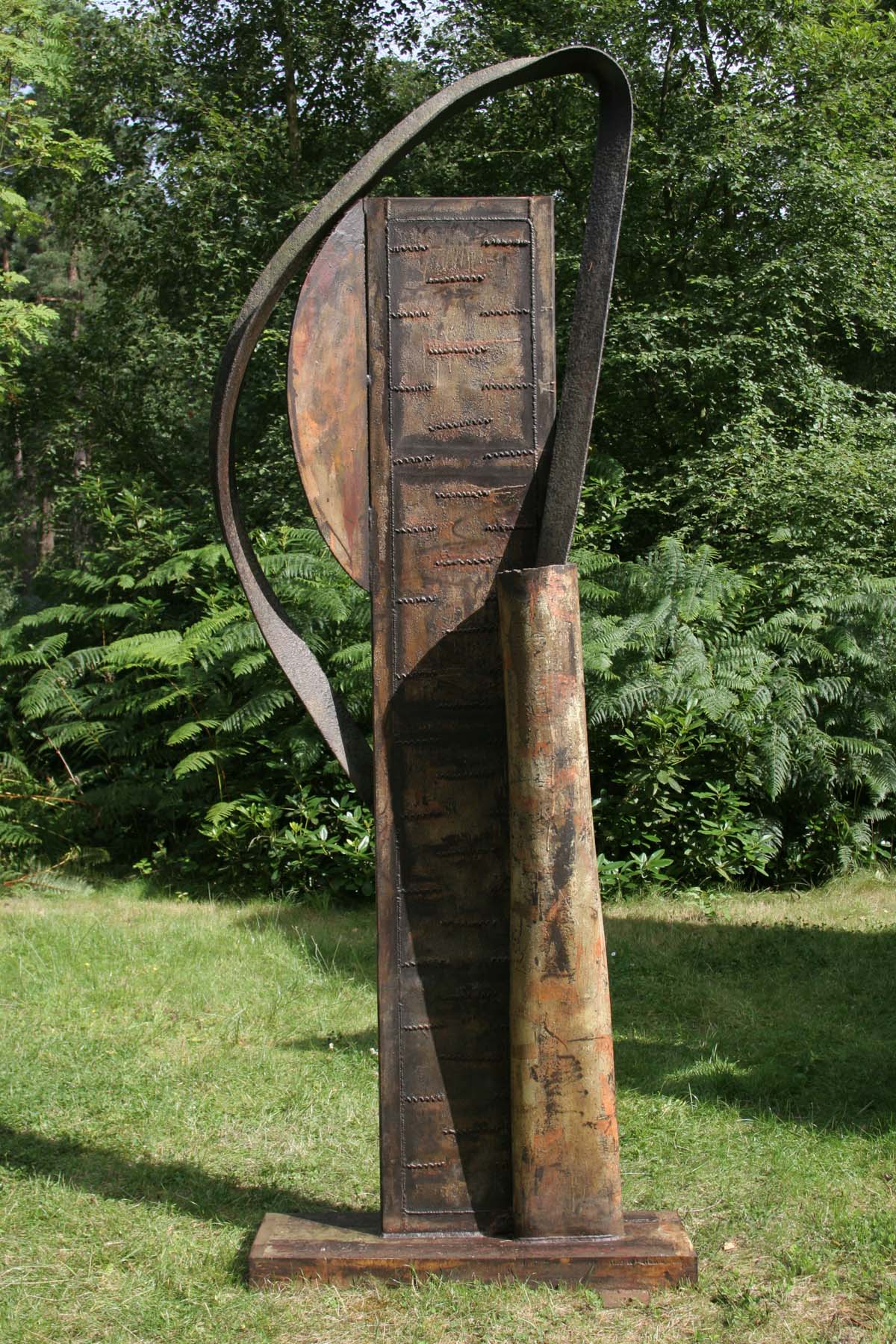 A contemporary welded steel sculpture of a tall abstract shape with curves and flat surfaces.