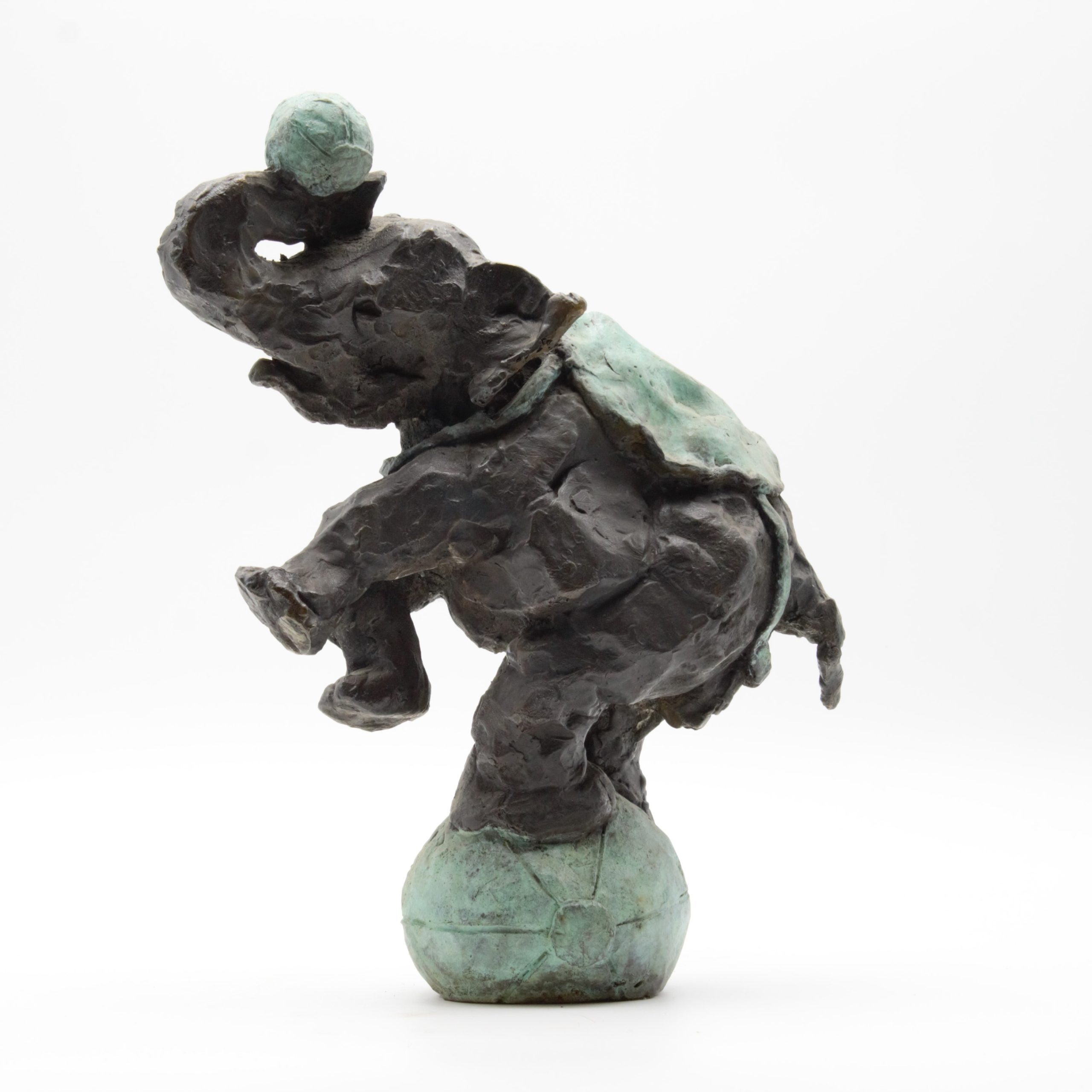 A figurative bronze sculpture of a circus elephant balancing on top of a ball while holding another with its trunk.
