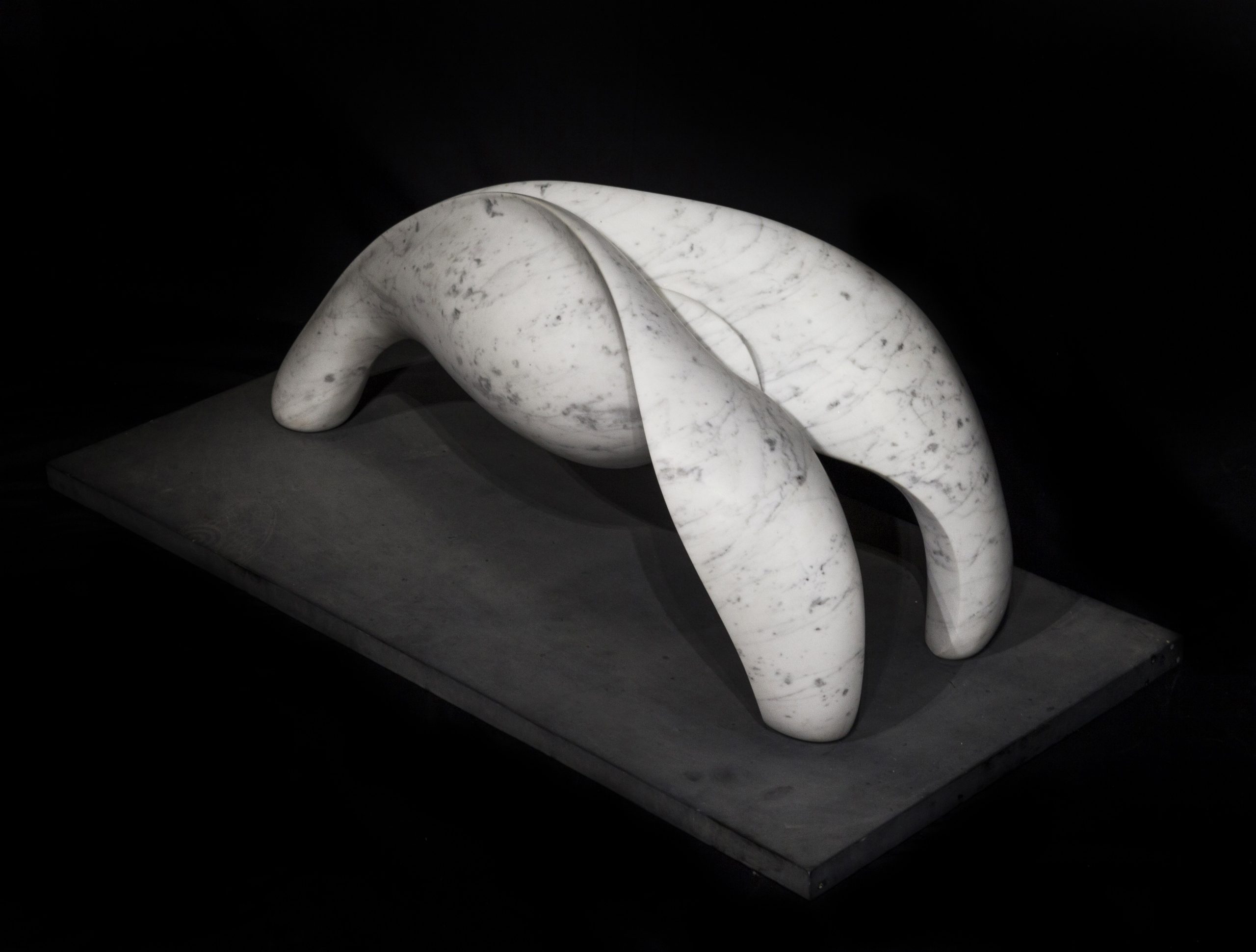 A abstract marble sculpture of a shape that splits in two and curls over.