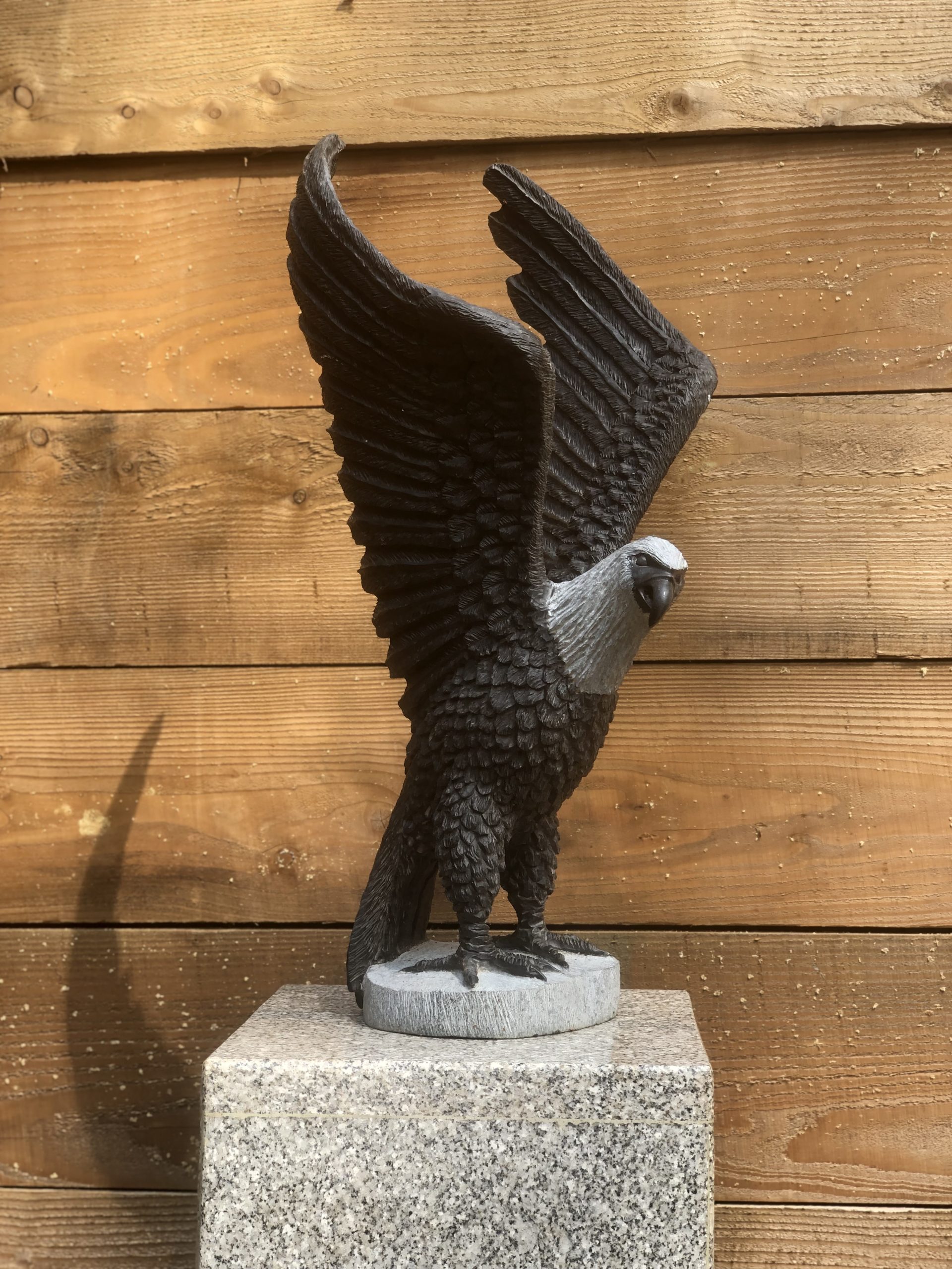 A Shona realism Springstone sculpture of a eagle with its wings spread open upwards.
