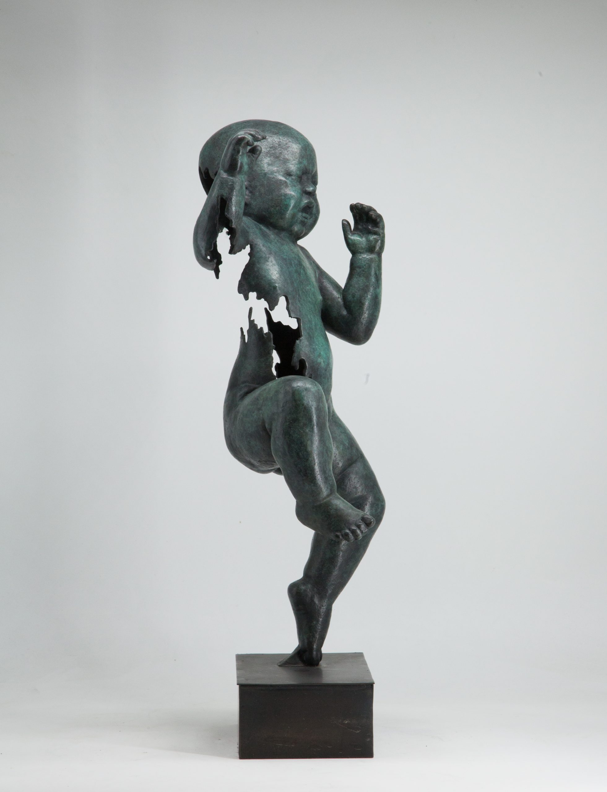 Figurative bronze sculpture of a newborn baby with both arms and one leg raised