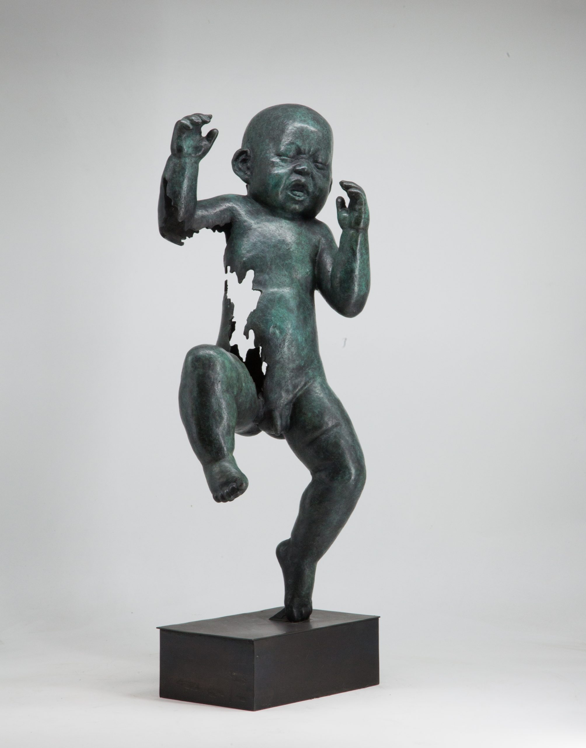 Figurative bronze sculpture of a newborn baby with both arms and one leg raised