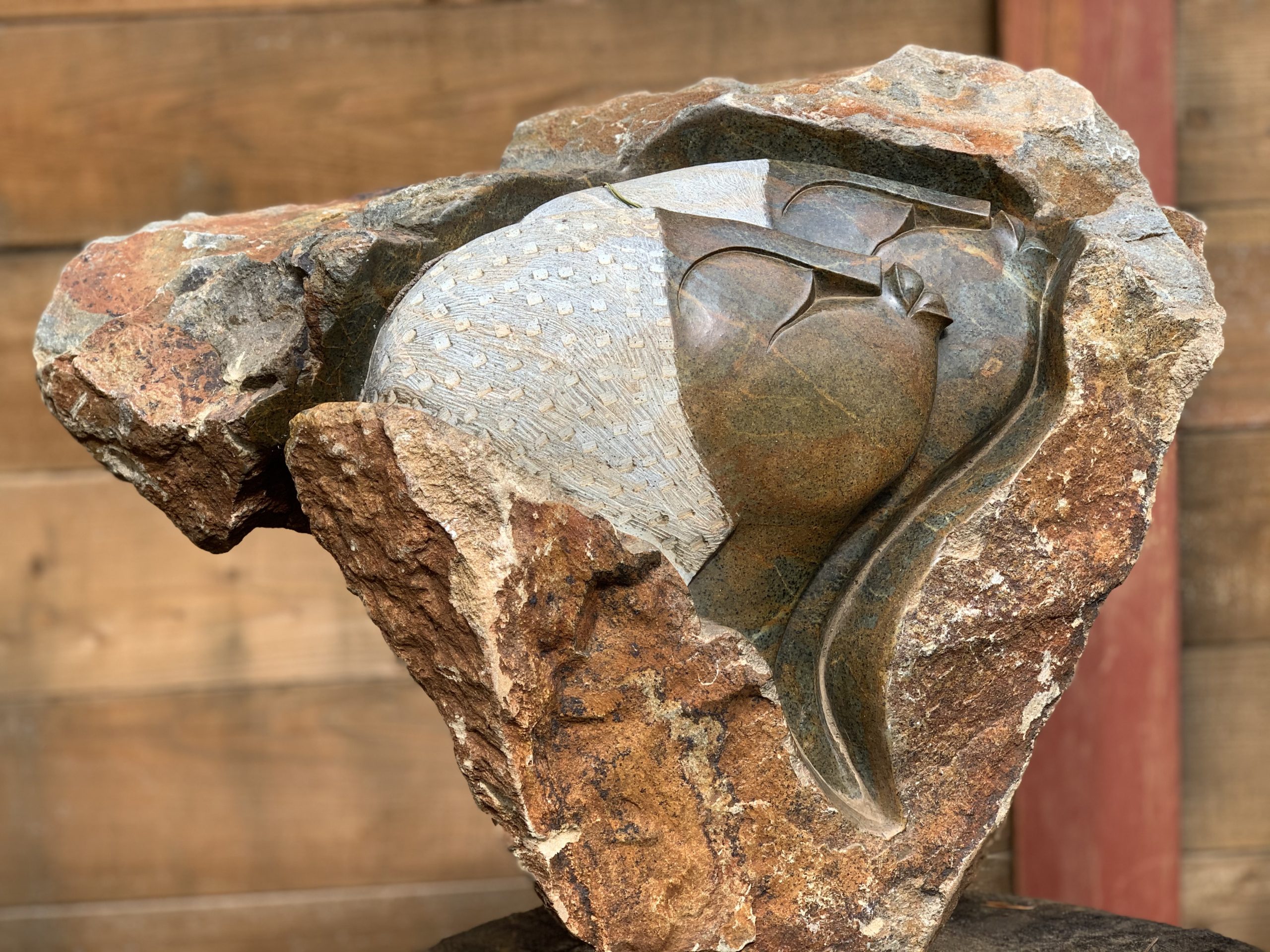 A shona serpentine stone sculpture of two men looking to the side.