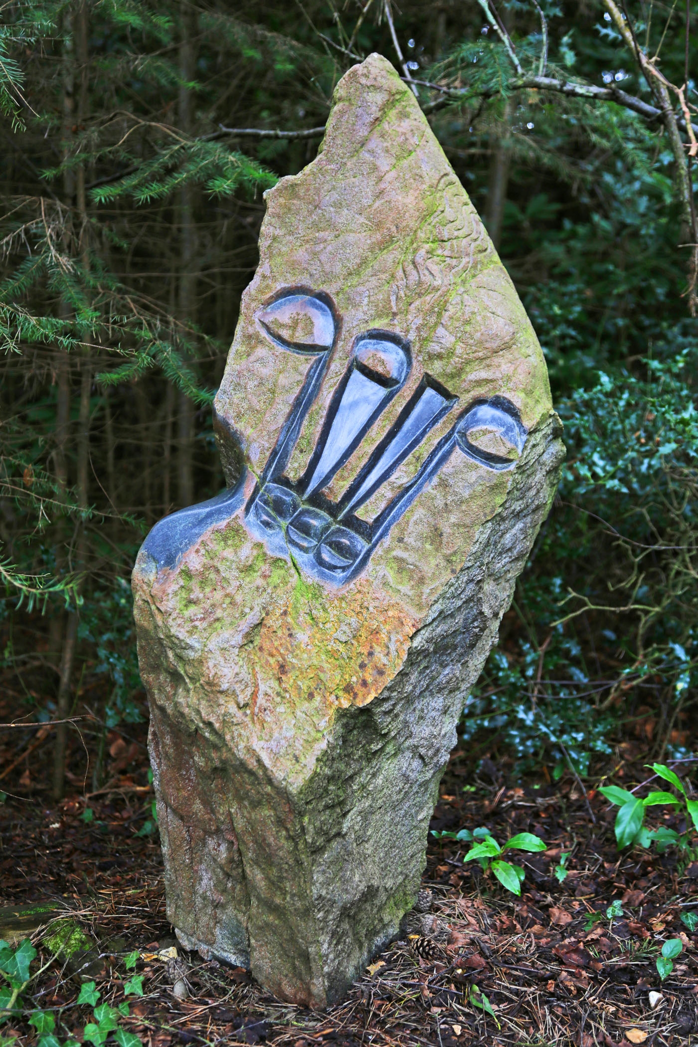 A shona springstone sculpture of a stone with an abstract carving in it.