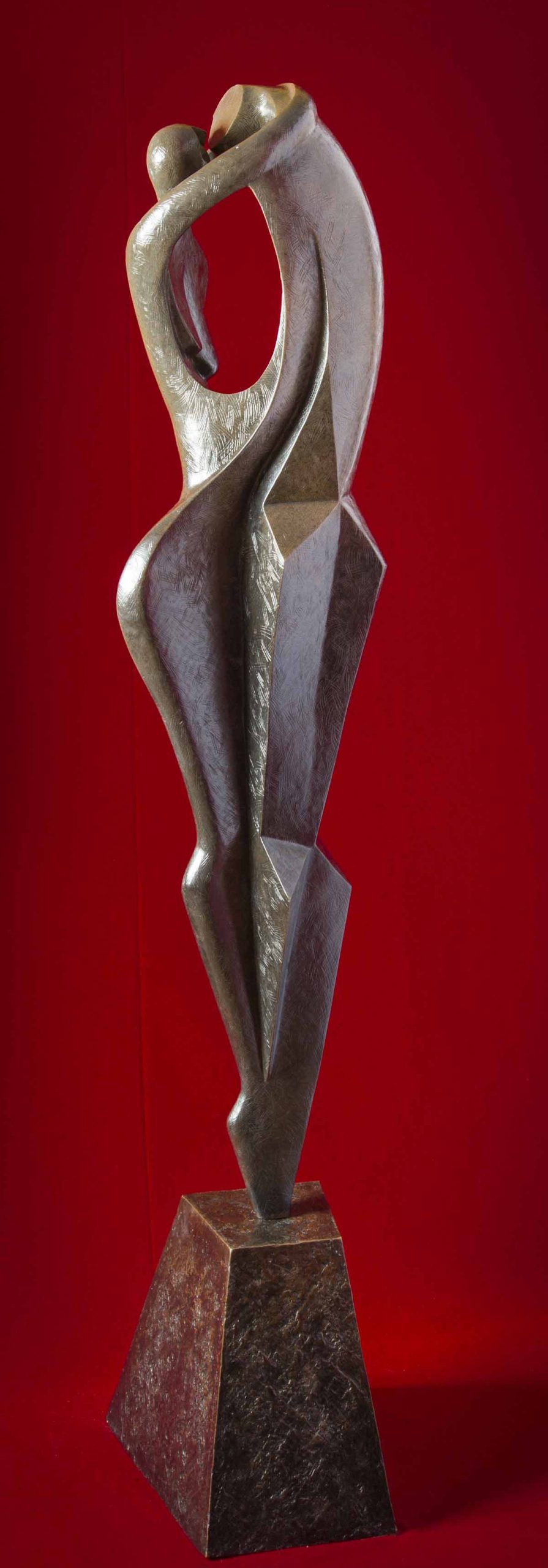 A figurative bronze sculpture of a man and a woman holding each other in an embrace.