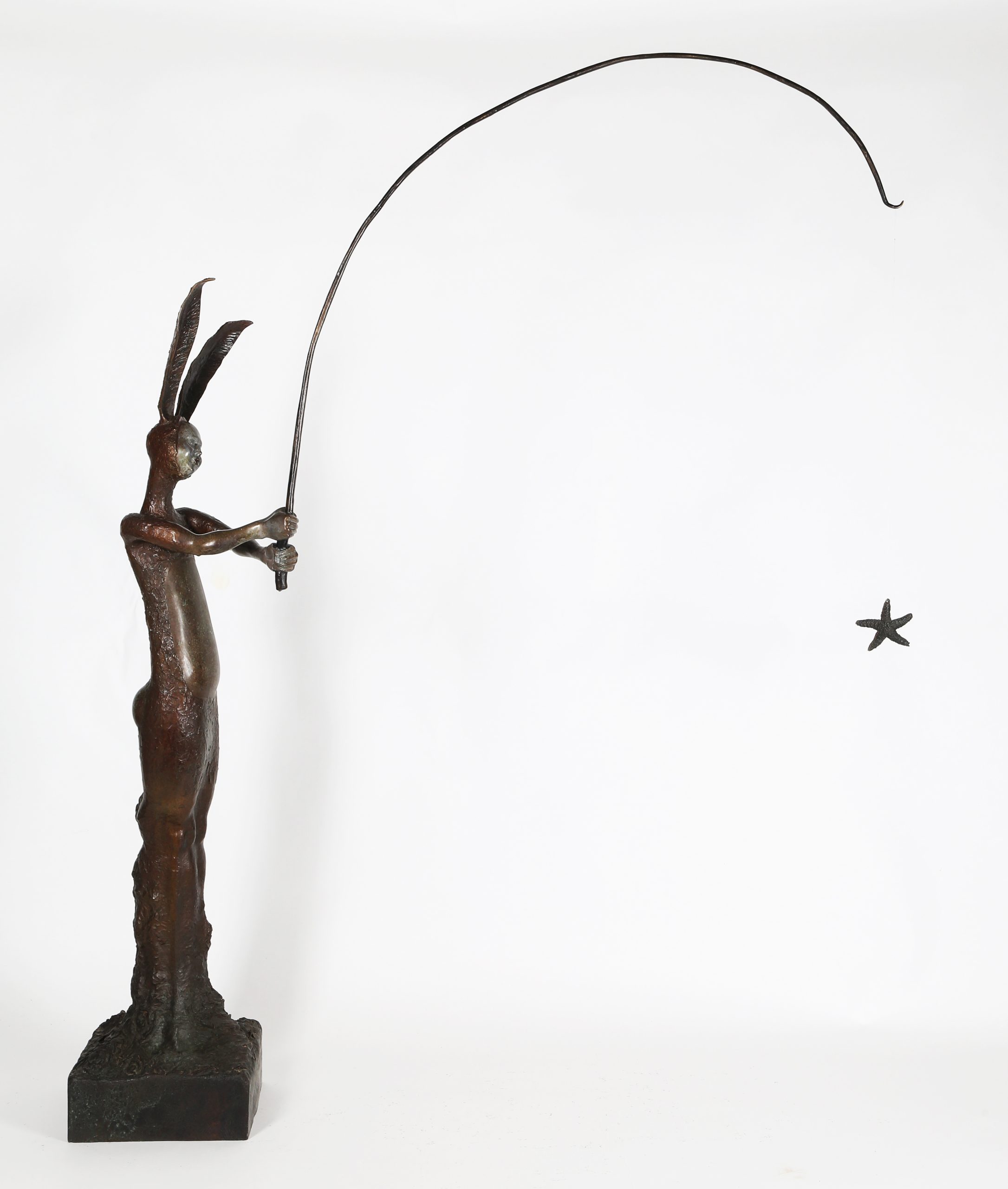 A figurative bronze sculpture of a person in a bunny outfit with a fishing rod.