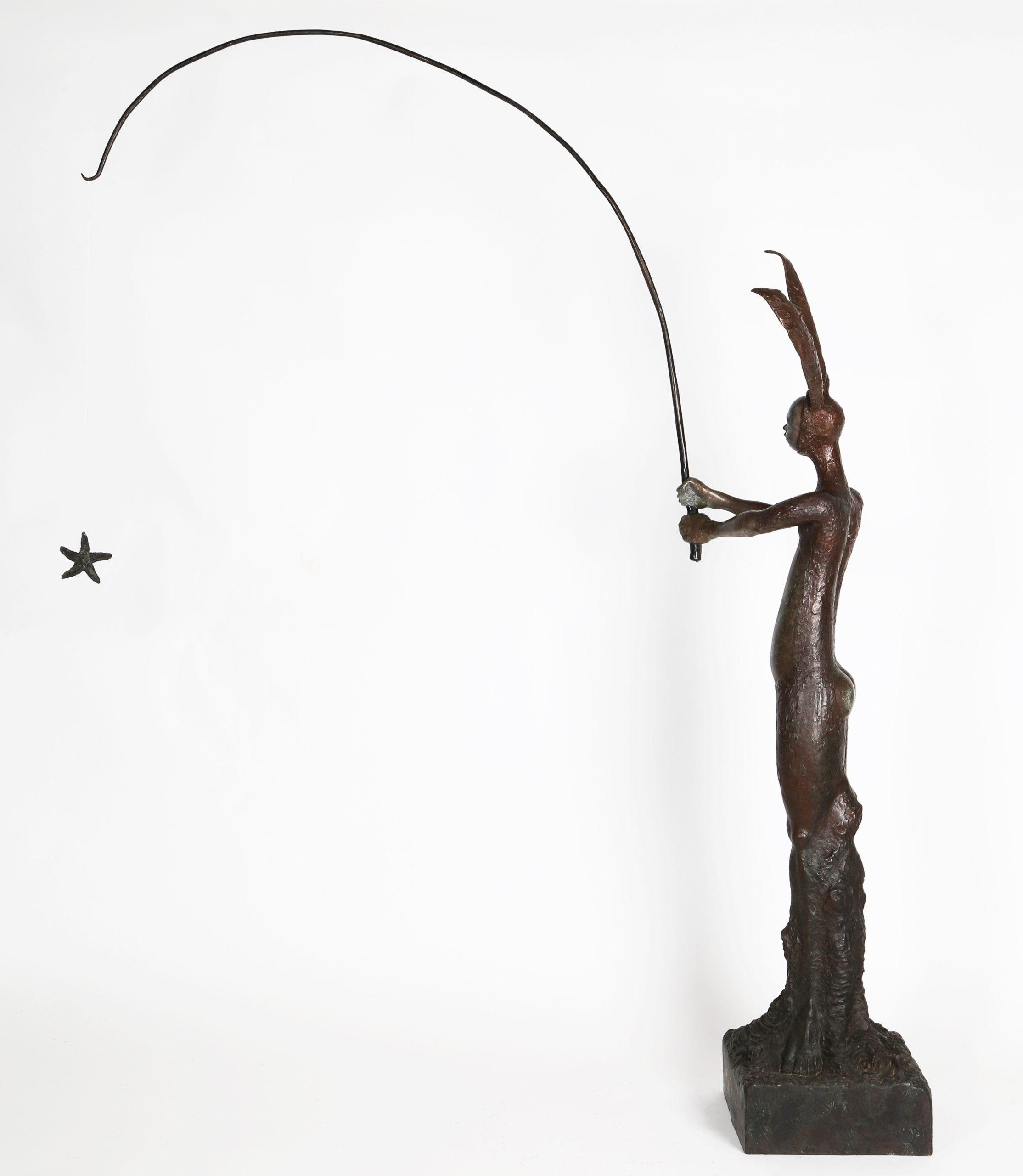 A figurative bronze sculpture of a person in a bunny outfit with a fishing rod.