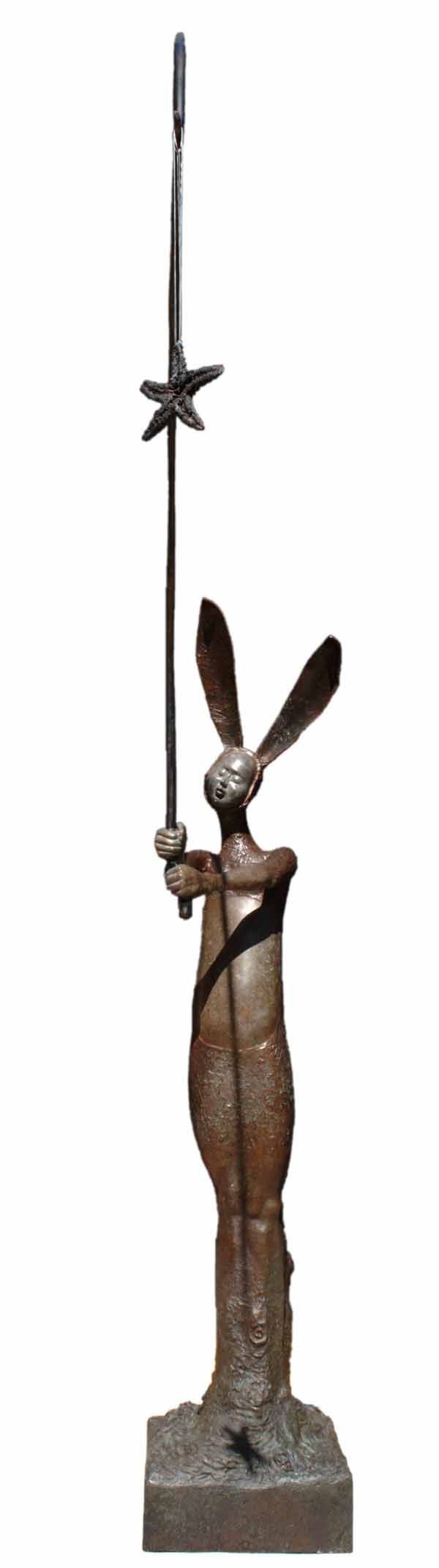 A figurative bronze sculpture of a person in a bunny outfit with a fishing rod.