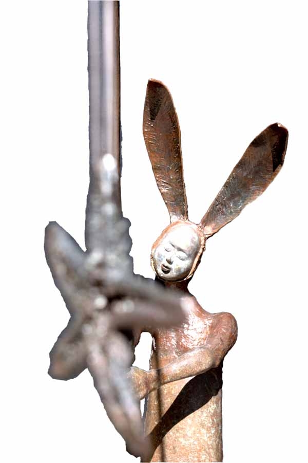 A figurative bronze sculpture of a person in a bunny outfit with a fishing rod.