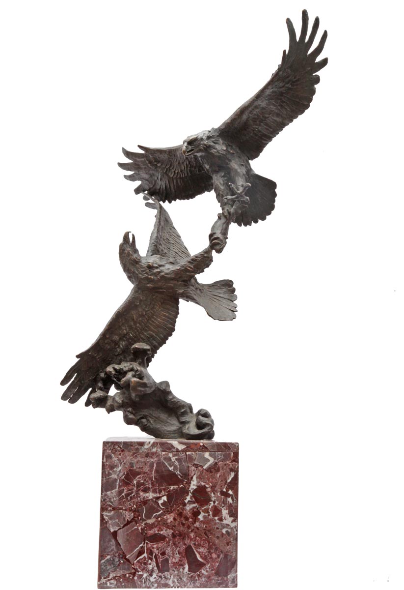 A figurative bronze sculpture of a pair of eagles fighting while in mid flight, mounted onto a block.