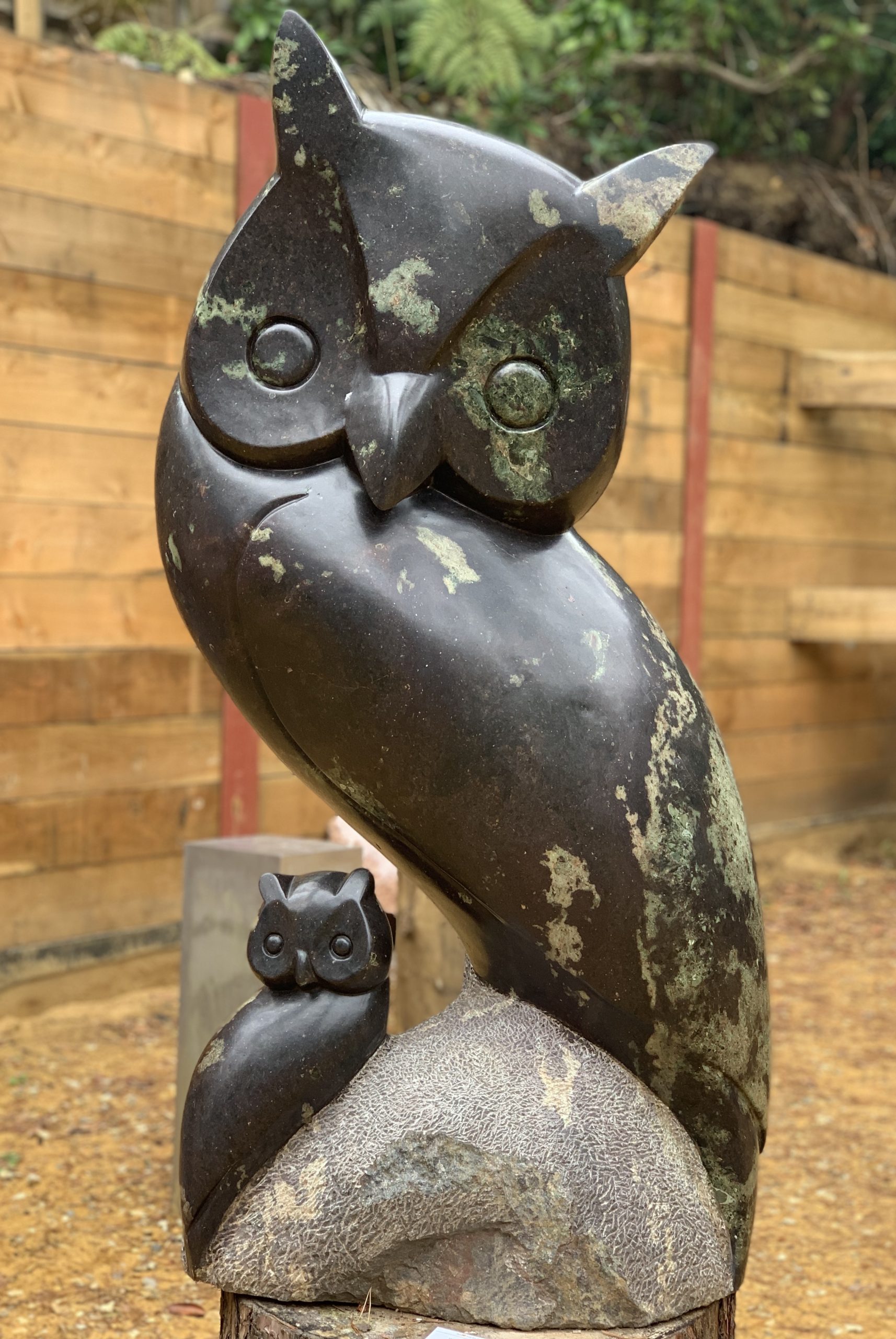 A shona cobalt stone sculpture of an owl with another smaller owl perched on a rock.