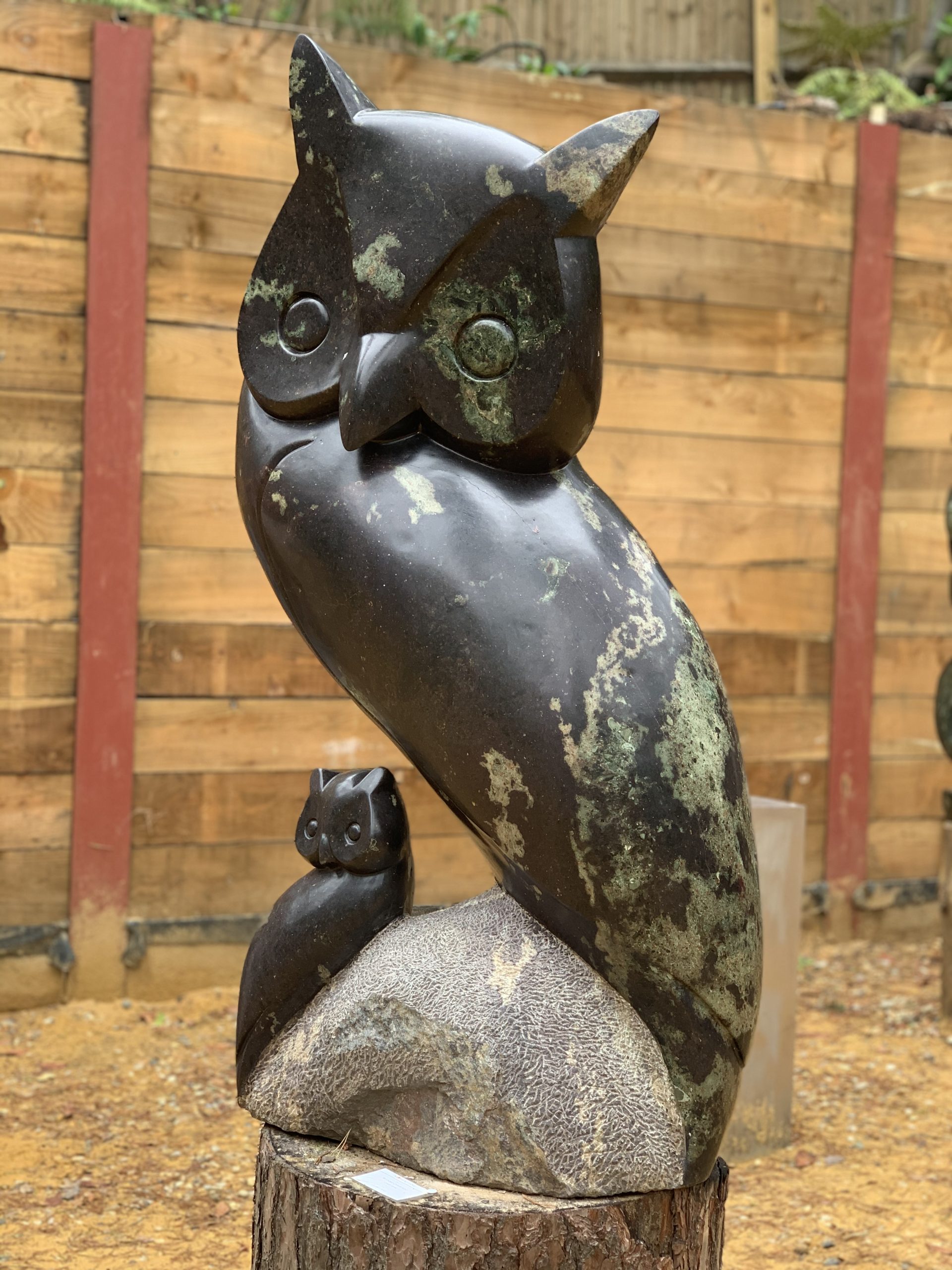 A shona cobalt stone sculpture of an owl with another smaller owl perched on a rock.